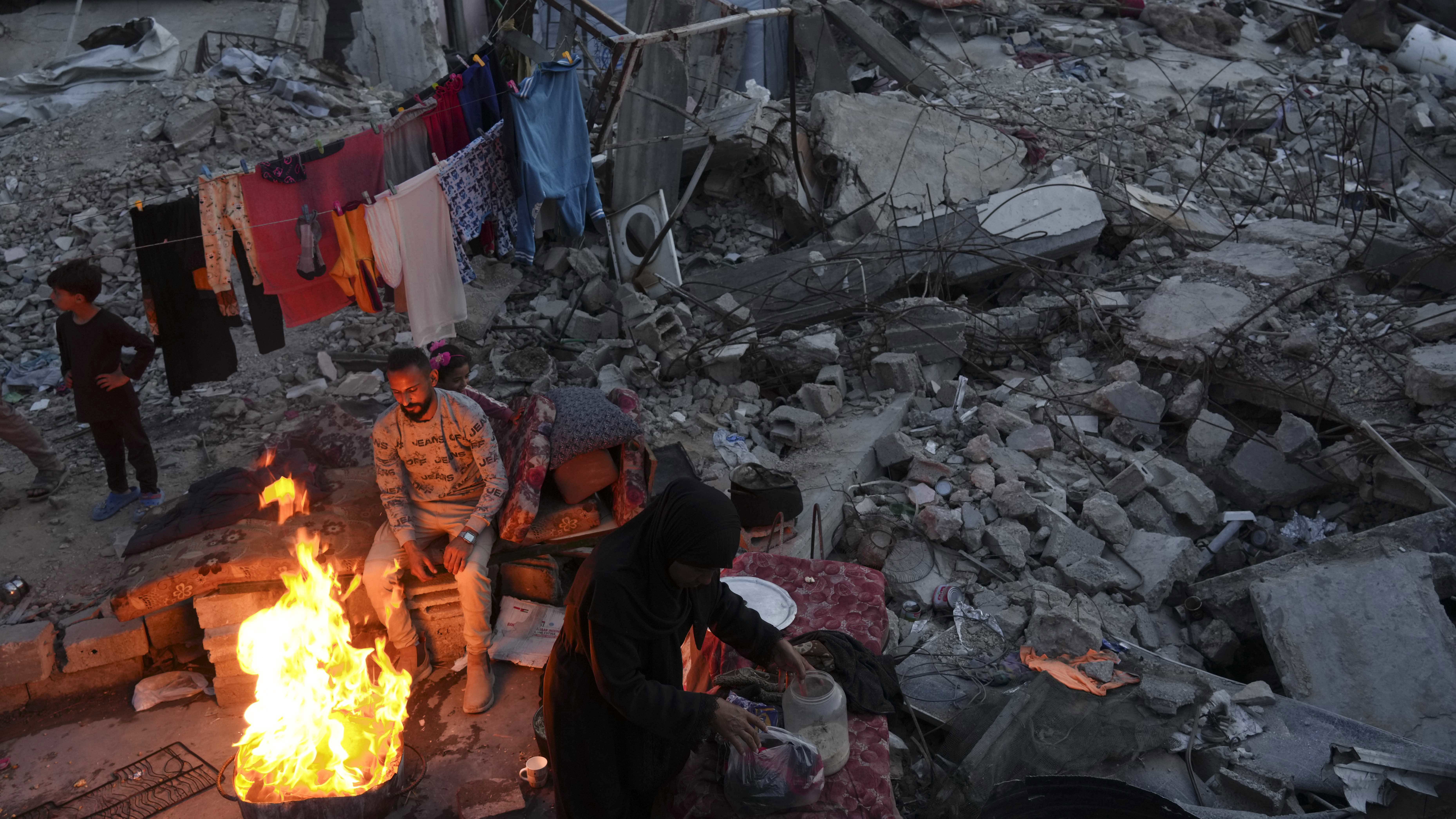 Members of Palestinian Marouf family cook outside their destroyed house by the Israeli army's air and ground offensive in Jabaliya, Gaza Strip.