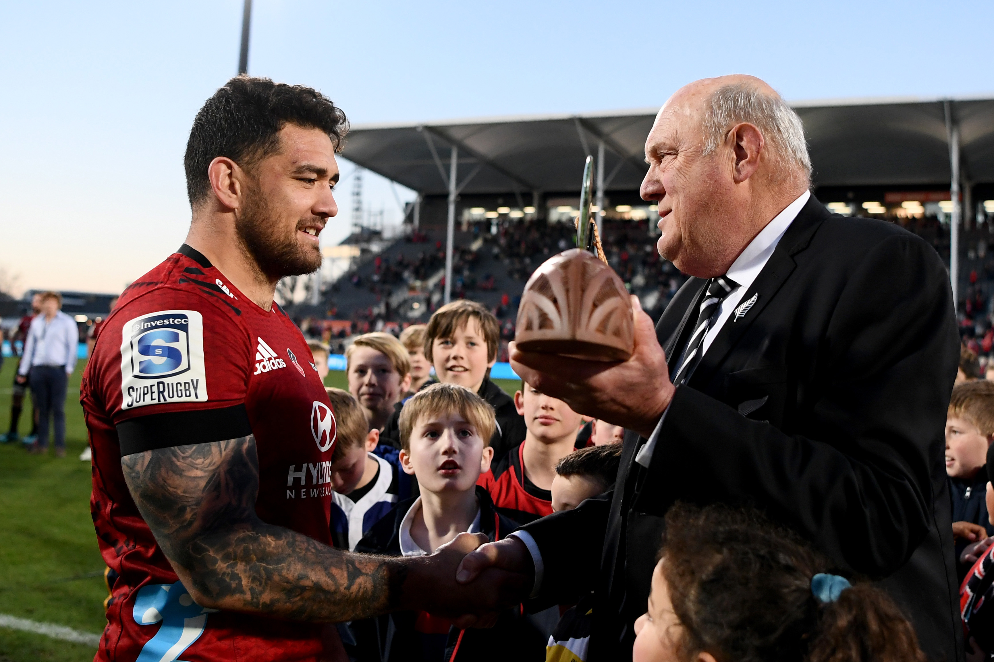 Codie Taylor receives the Super Rugby Aotearoa trophy from NZR chairman Stewart Mitchell.