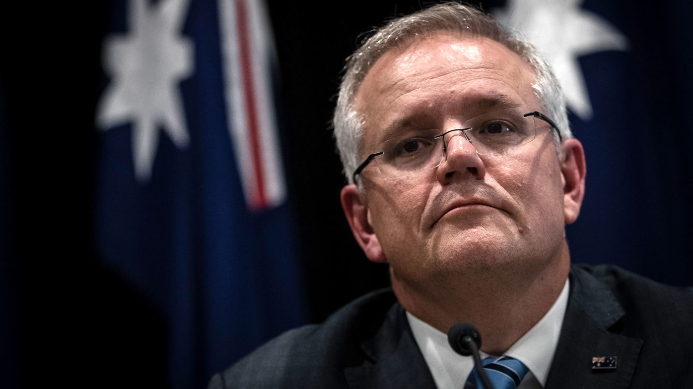 Scott Morrison sits in front of the Australian flag.