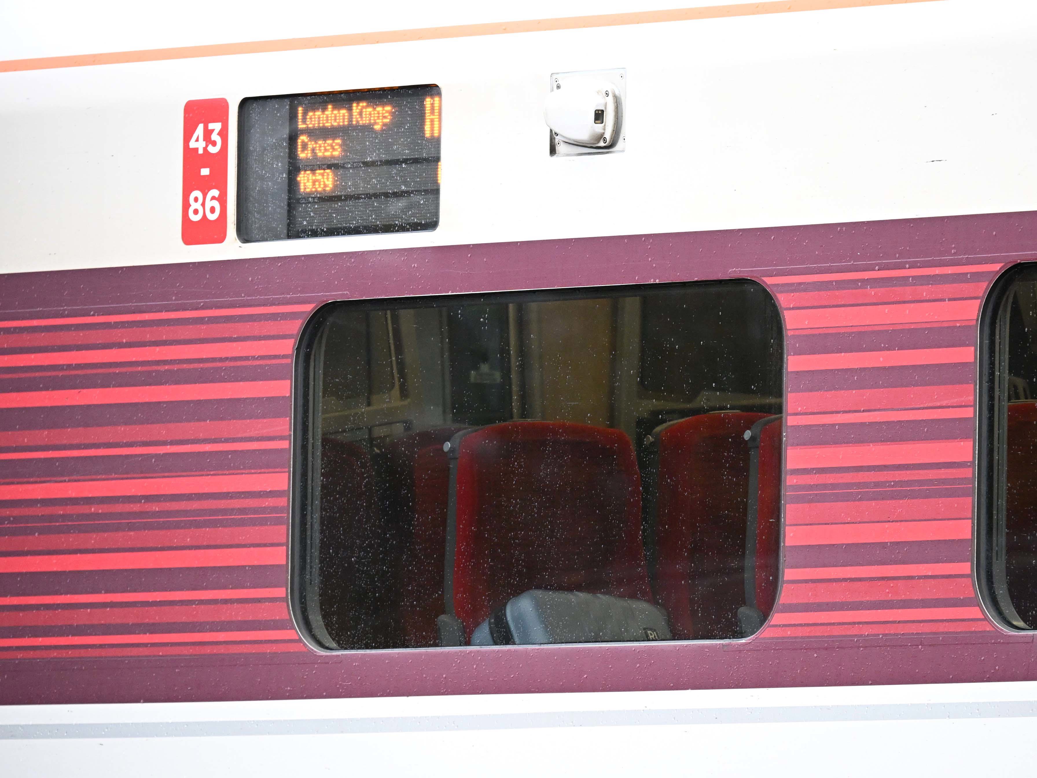 A passengers belongings are seen through the window as emergency services attend to the train.