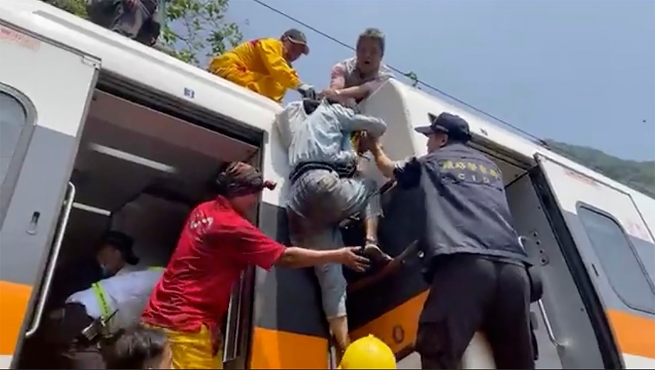 A passenger is helped to climb out of a derailed train in Hualien County in eastern Taiwan.