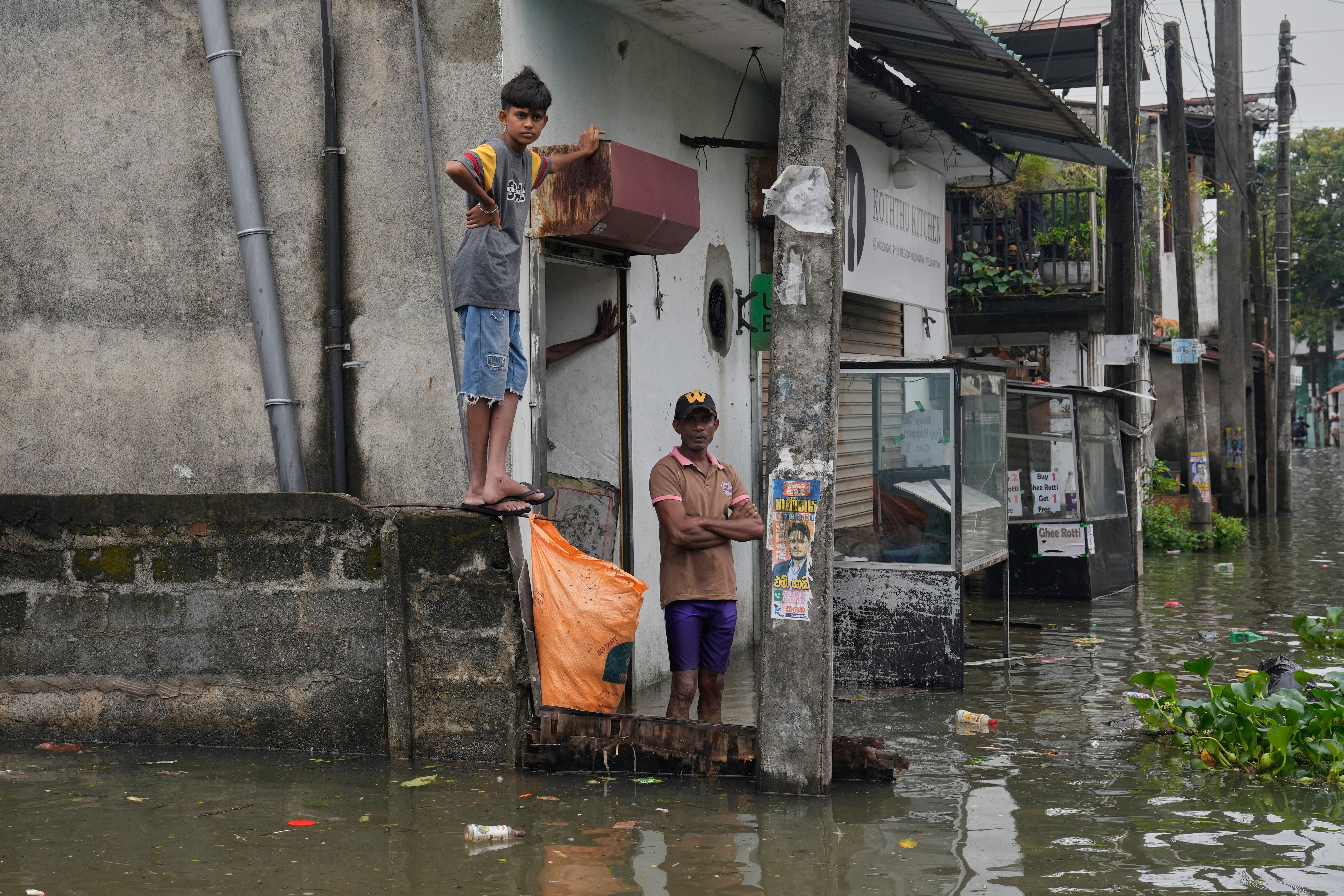 People stranded by floods wait in their submerged neighborhood in Colombo, Sri Lanka, Saturday, Nov, 29, 2025. (AP Photo/Eranga Jayawardena)