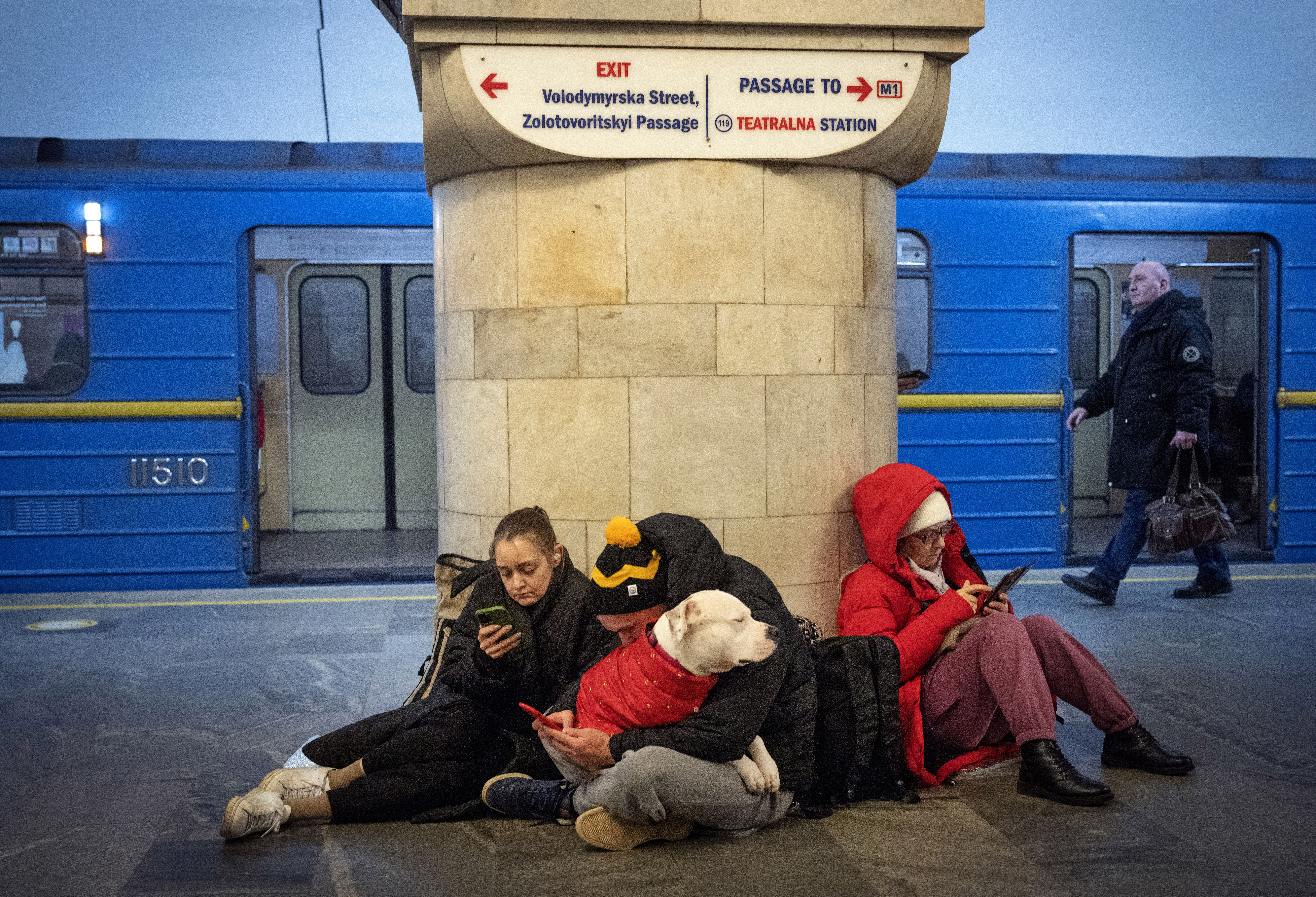 People sit in the subway station being used as a bomb shelter during a rocket attack in Kyiv, Ukraine, Thursday, Dec. 29, 2022. 