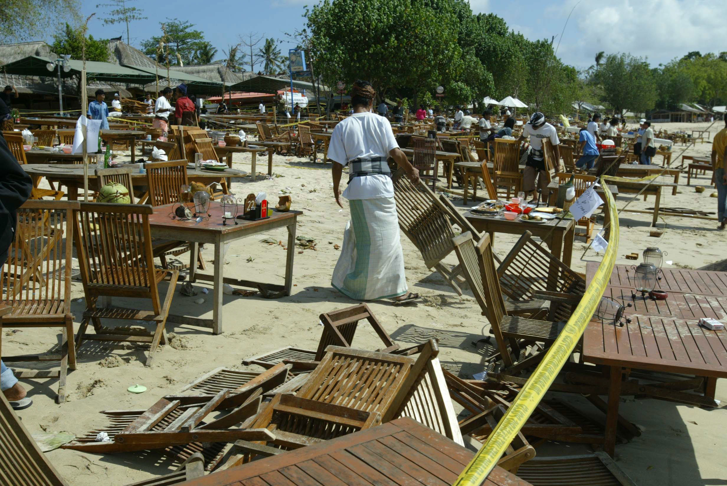 A man starts cleaning up on Jimbaran beach following the 2005 Bali bombings.