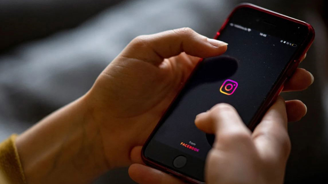 The logo of the Instagram app is seen on the screen of a smartphone in 2021.