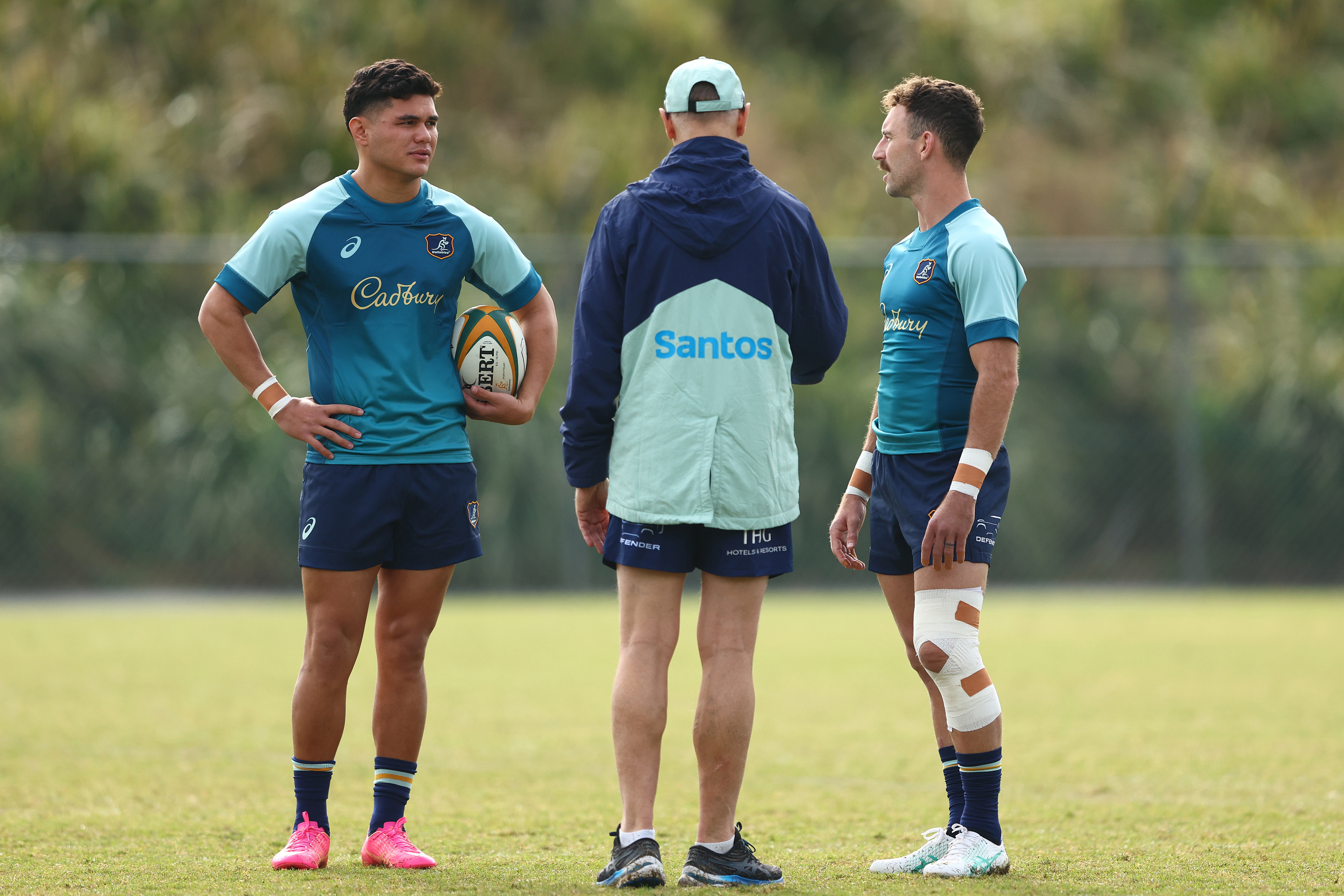 Joe Schmidt talks with Noah Lolesio and Nic White during a Wallabies training session.