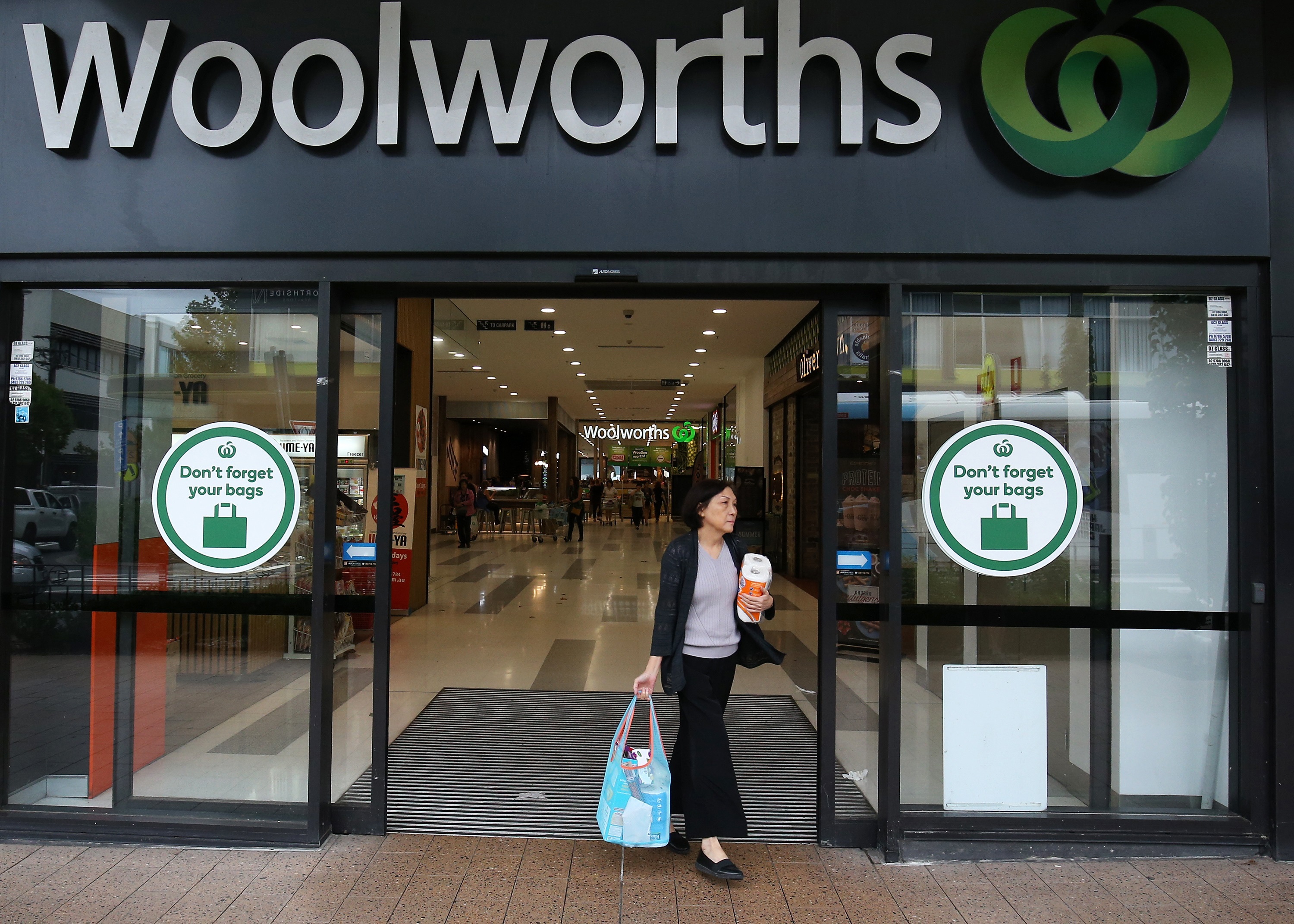 A customer exits a Woolworths Group Ltd. supermarket after purchasing paper towels in Sydney, Australia, on Wednesday, Mar. 4, 2020. Australia's four biggest lenders have heeded the prime ministers plea to "do their bit" to help the country weather the expected economic hit from the coronavirus, by passing on the central banks latest interest-rate cut in full. Photographer: Brendon Thorne/Bloomberg