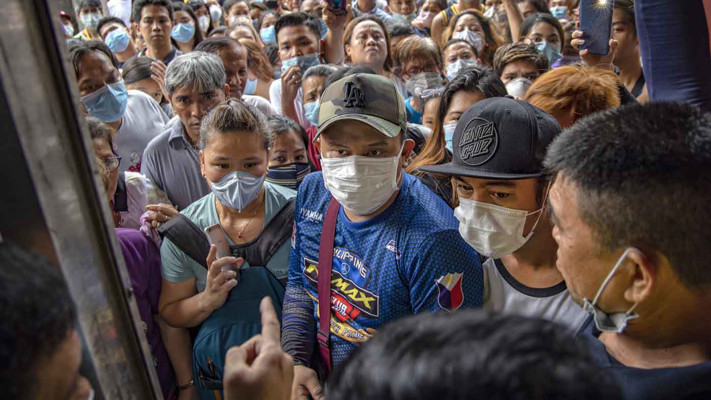 Filipinos hoping to buy face masks crowd outside a medical supply shop that was raided by police for allegedly hoarding and overpricing the masks, as public fear over China's Wuhan Coronavirus grows, on January 31, 2020 in Manila, Philippines.