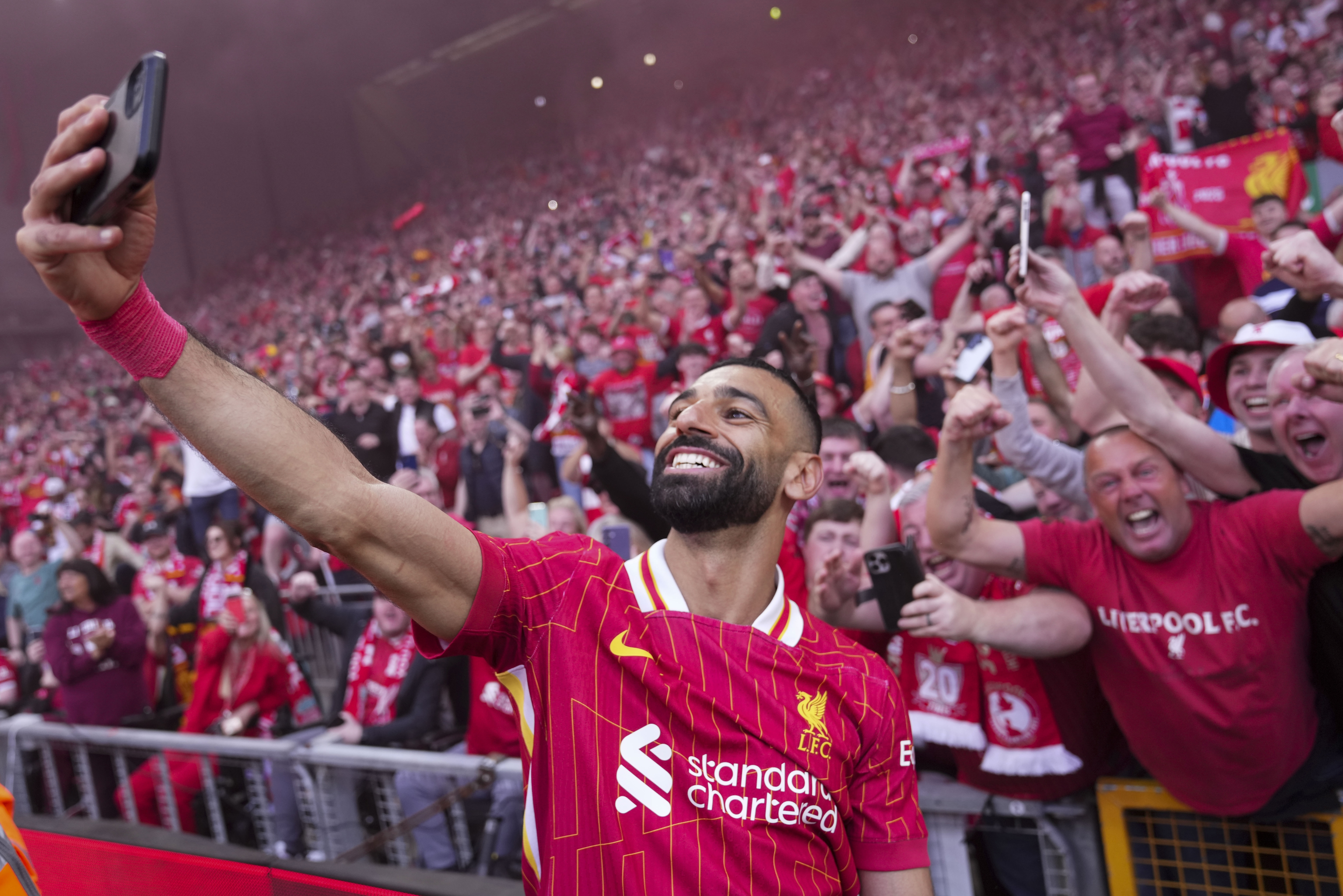 Liverpool's Mohamed Salah celebrates by taking a selfie after winning the English Premier League soccer match between Liverpool and Tottenham Hotspur and clinching the Premier League title at Anfield in Liverpool, England, Sunday, April 27, 2025. (AP Photo/Jon Super)