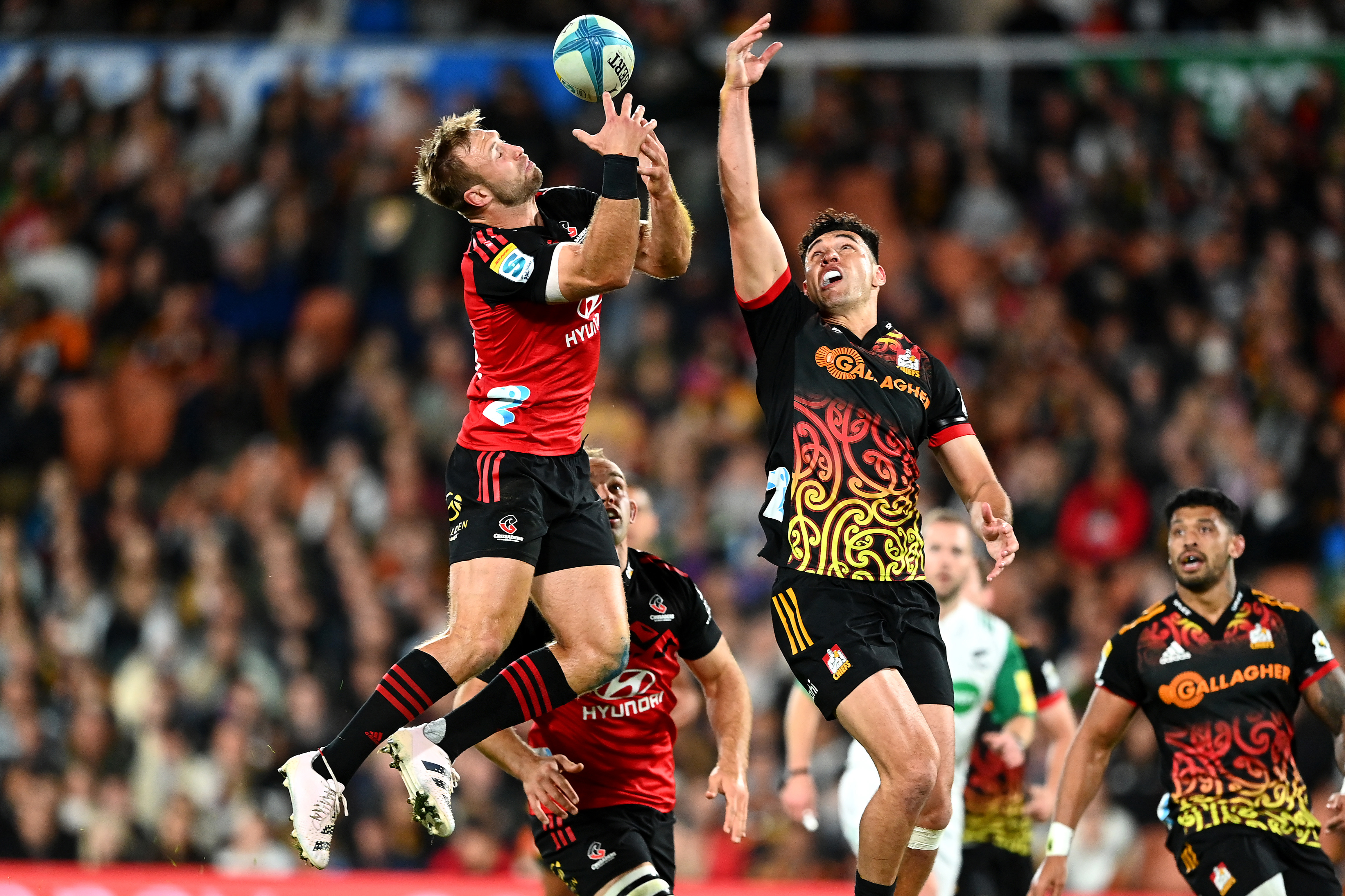 Braydon Ennor of the Crusaders and Shaun Stevenson of the Chiefs compete for the ball during round 10 of Super Rugby Pacific.