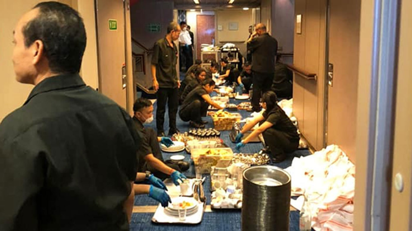 A photo on board the cruise ship Zaandam shows crews packed together while collecting meals.