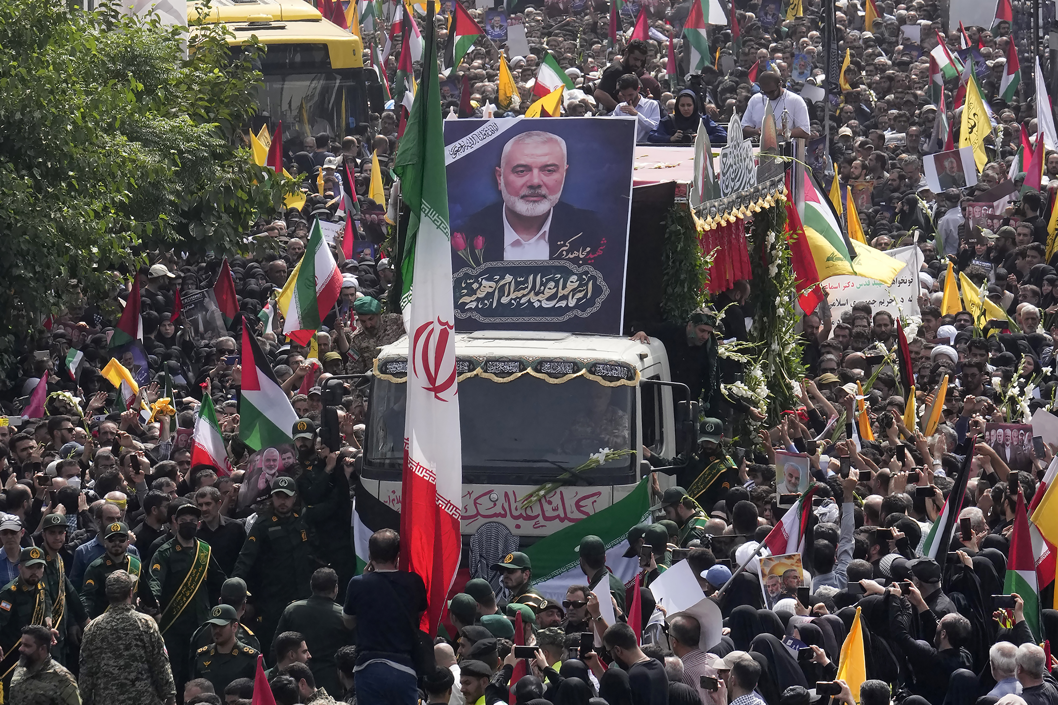 Iraníes siguen a un camión, en el centro, que transporta los ataúdes del líder de Hamas, Ismail Haniyeh, y su guardaespaldas, quienes fueron asesinados en un asesinato atribuido a Israel el miércoles, durante su ceremonia fúnebre en la plaza Enqelab-e-Eslami (Revolución Islámica) en Teherán, Irán, el jueves 1 de agosto de 2024. (Foto AP/Vahid Salemi)