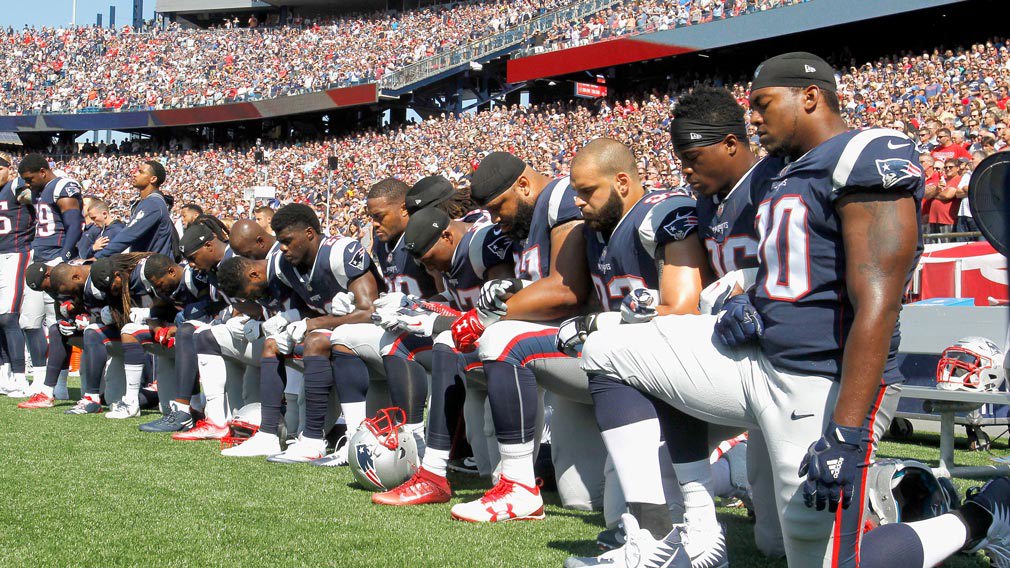 Members of the New England Patriots kneel on the sidelines as the National Anthem is played before a game against the Houston Texans at Gillette Stadium. (AFP)