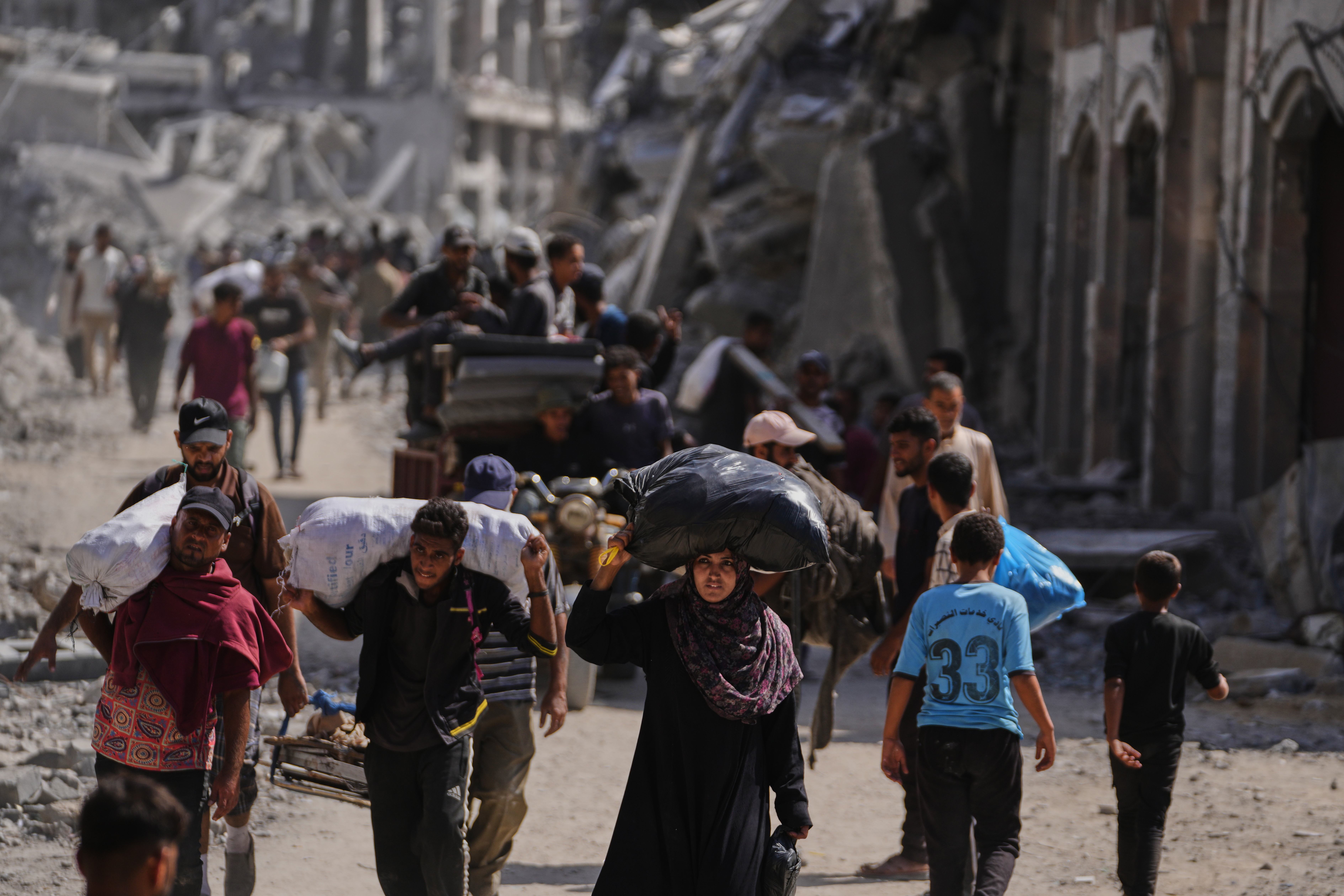 Displaced Palestinians walk along the coastal road as they move in the direction of Gaza City,