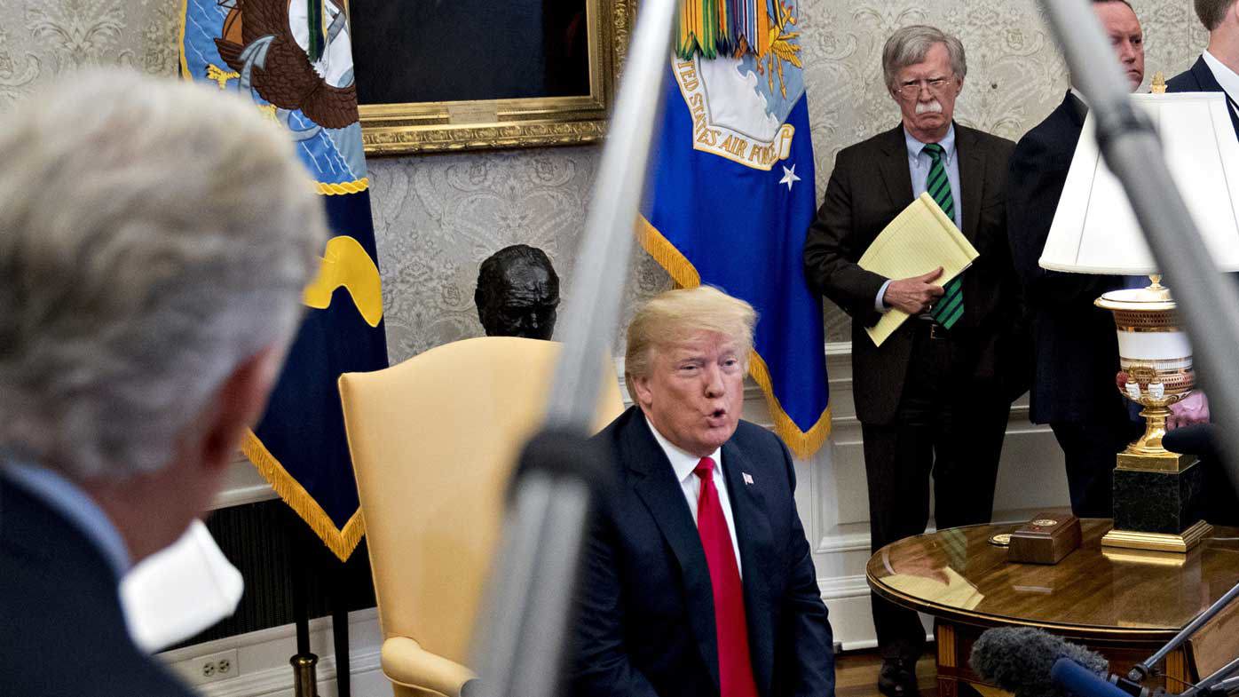 John Bolton listens to Donald Trump speaking in the Oval Office. (AAP)