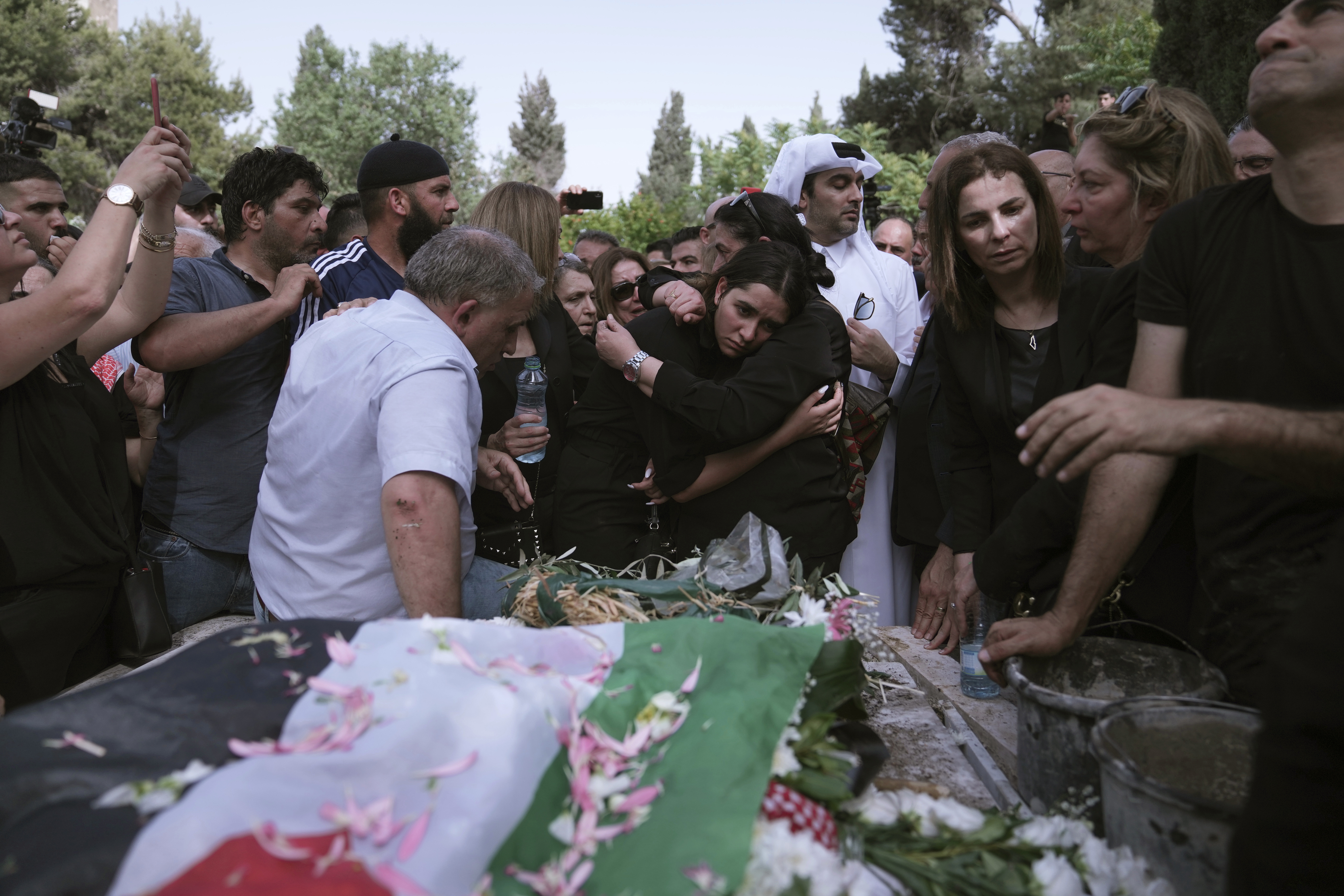 Mourners gather to bury slain Al Jazeera veteran journalist Shireen Abu Akleh in Jerusalem, Friday, May 13, 2022. Abu Akleh, a Palestinian-American reporter who covered the Mideast conflict for more than 25 years, was shot dead Wednesday during an Israeli military raid in the West Bank town of Jenin.(AP Photo/Mahmoud Illean)