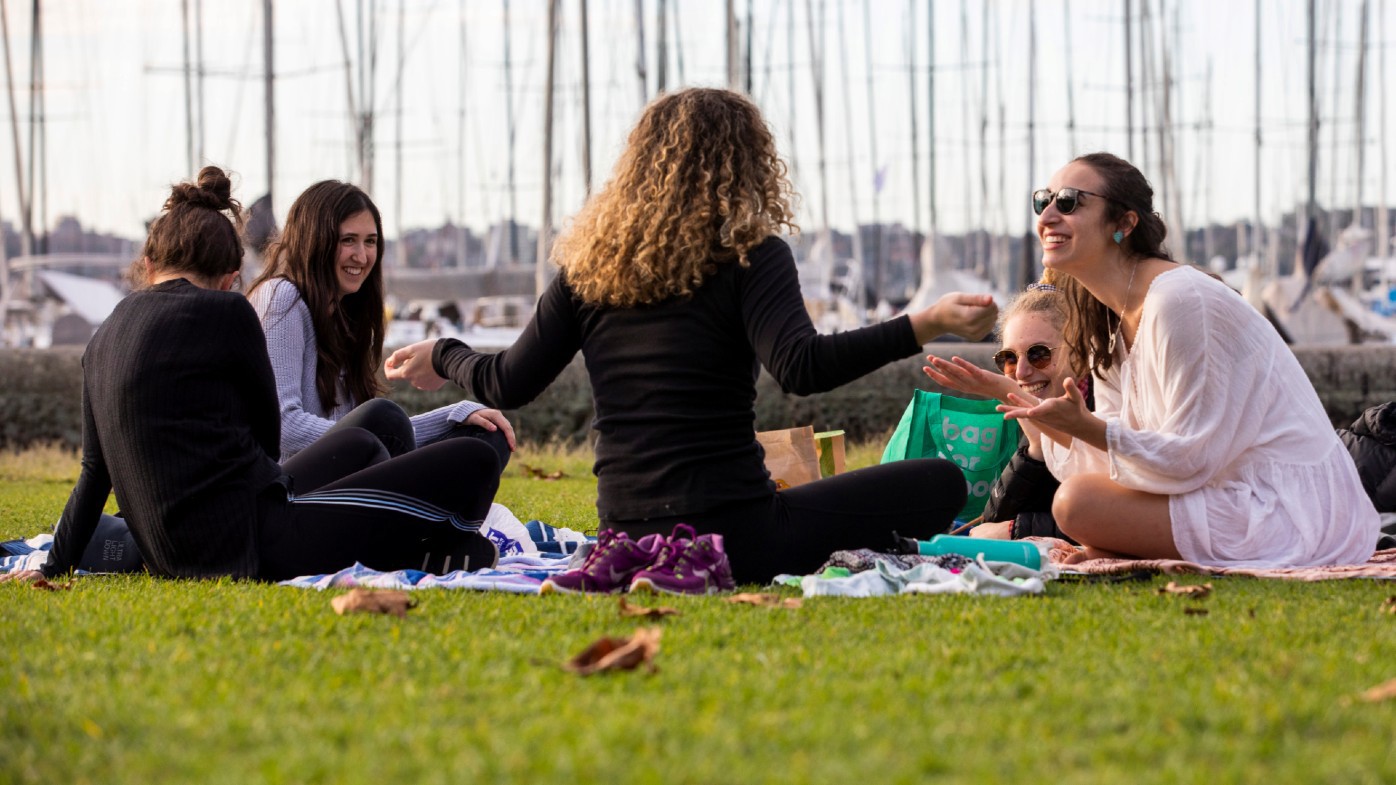 Friends catch up after lockdown restrictions ease at Rushcutters Bay Park in Sydney.