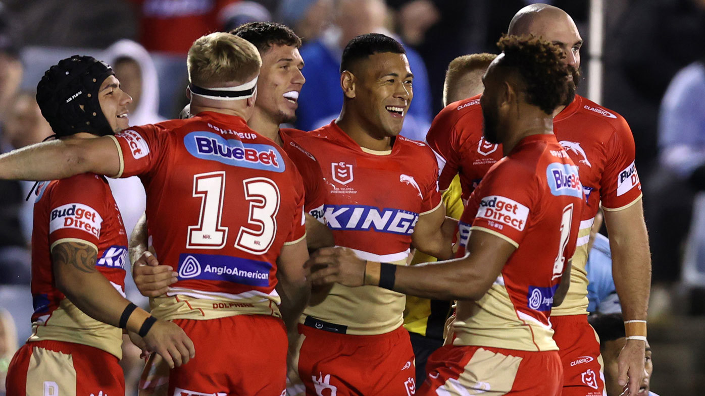 Dolphins players celebrate with Jake Averillo after he scored a try against the Sharks in round 15.