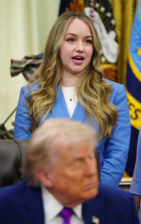 Donald Trump with his eyes closed as Monique Pruitt speaks behind him.