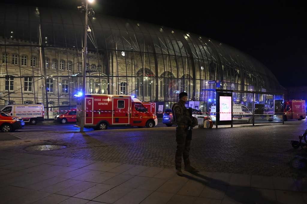 A soldier guards the train station after two trams collided in France