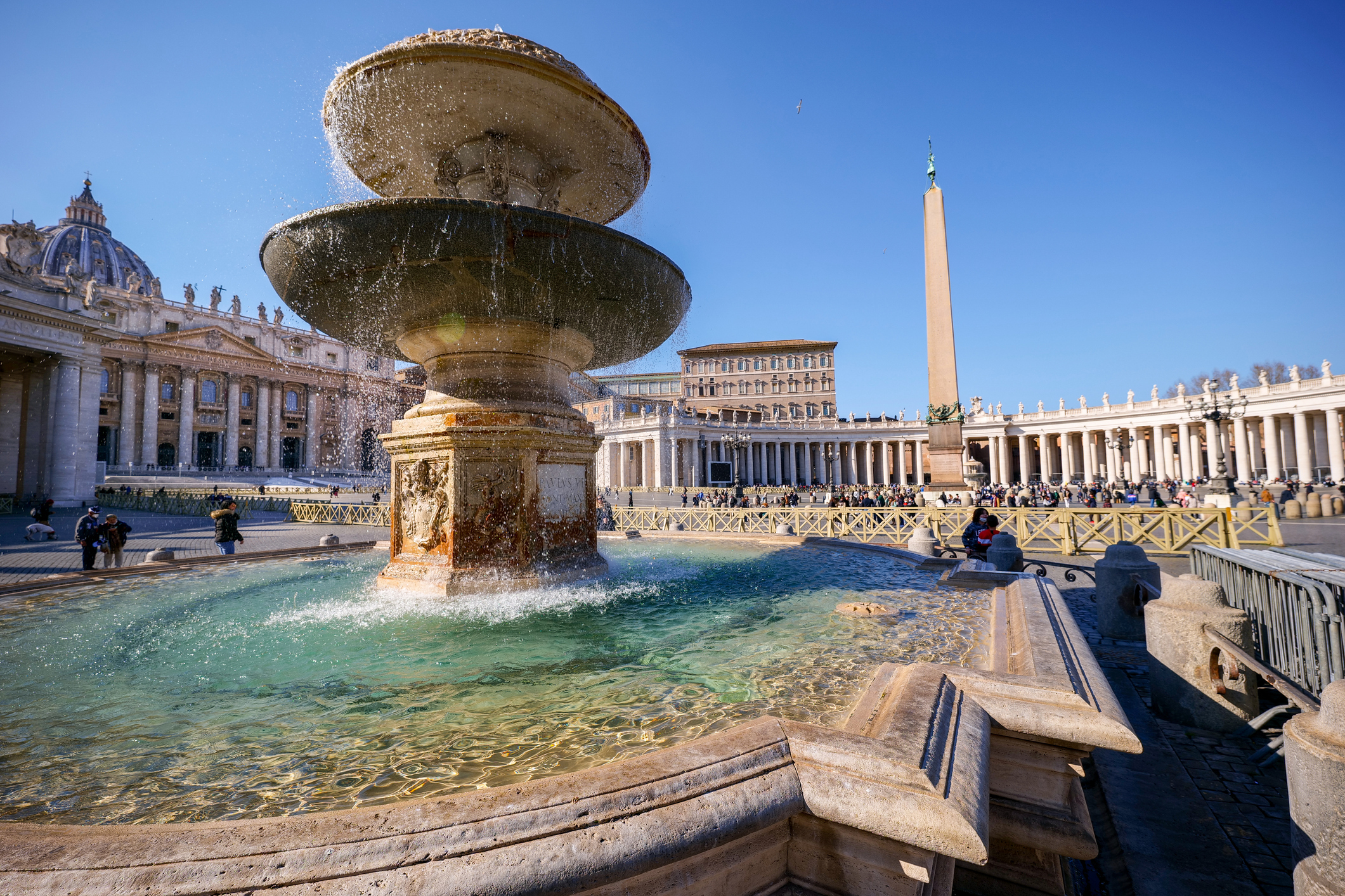 Vatican, March 09 -- A Bernini fountain in the majestic square of St Peter's Basilica, surrounded by the colonnade designed and built by Bernini himself in 1655. Characterized by giant columns and pilasters, the immense facade of San Pietro (118 meters wide and 48 high), was conceived by the architect Carlo Maderno to complete Michelangelo's previous project and built between 1608 and 1614. The Basilica of St. Peter's is the center of the Catholic religion, one of the most visited places in the 