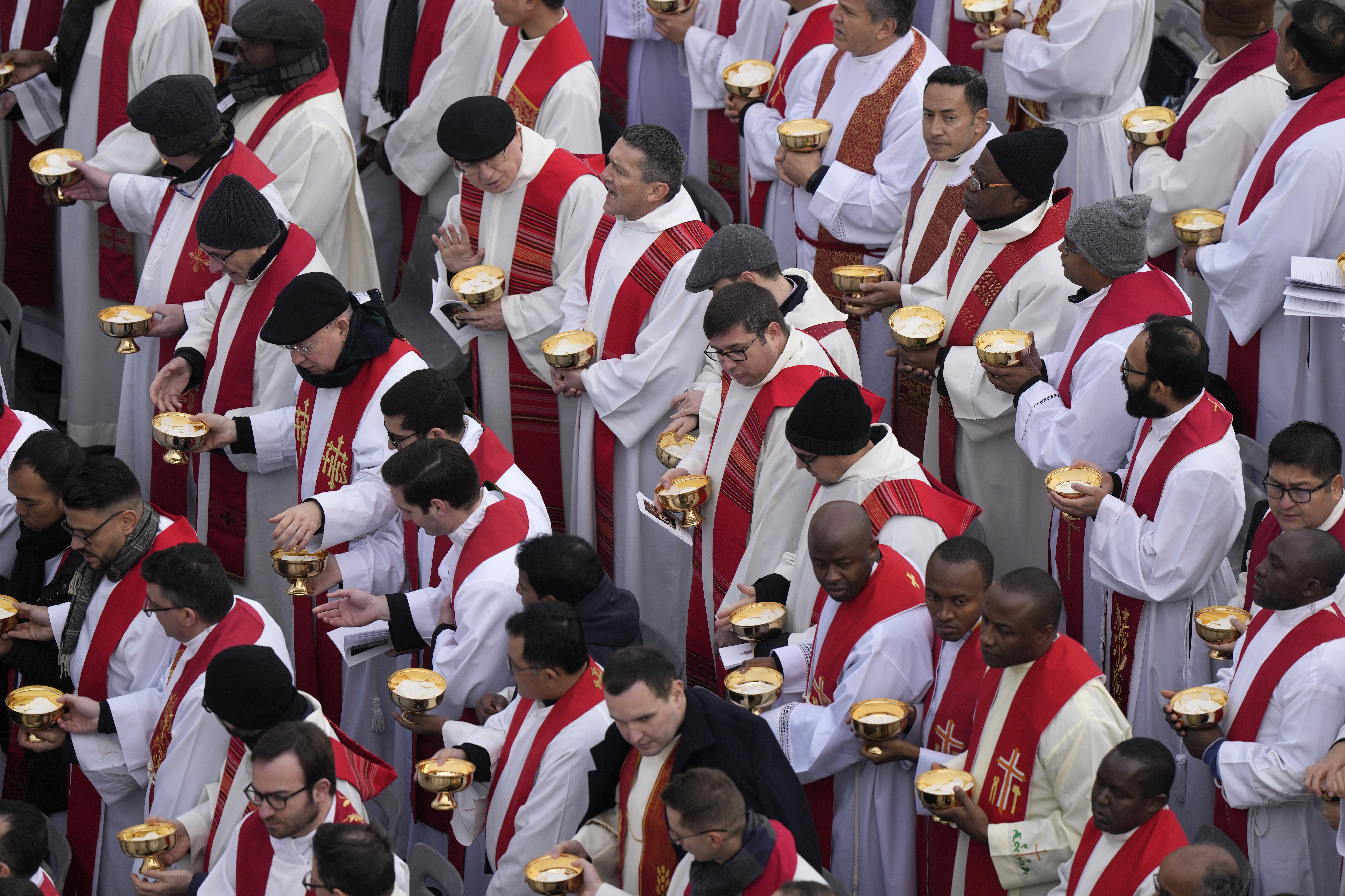 Priests prepare for the holy communion during the funeral mass for late Pope Emeritus Benedict XVI in St. Peter's Square at the Vatican, Thursday, Jan. 5, 2023. Benedict died at 95 on Dec. 31 in the monastery on the Vatican grounds where he had spent nearly all of his decade in retirement. (AP Photo/Ben Curtis)