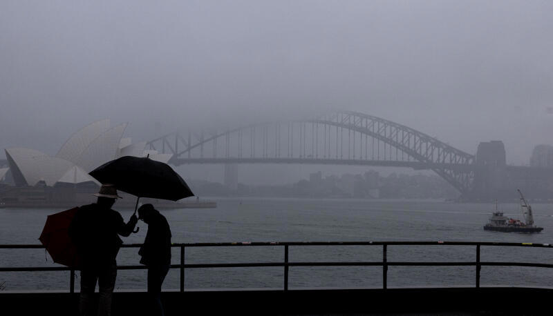 People are seen braving the rain and fog at Mrs Macquaries Chair this morning, Friday, 22 August 2025. After weeks of persistent rain, parts of the NSW coast have now recorded their wettest August in 126 years. Photo: Sam Mooy / The Sydney Morning Herald
