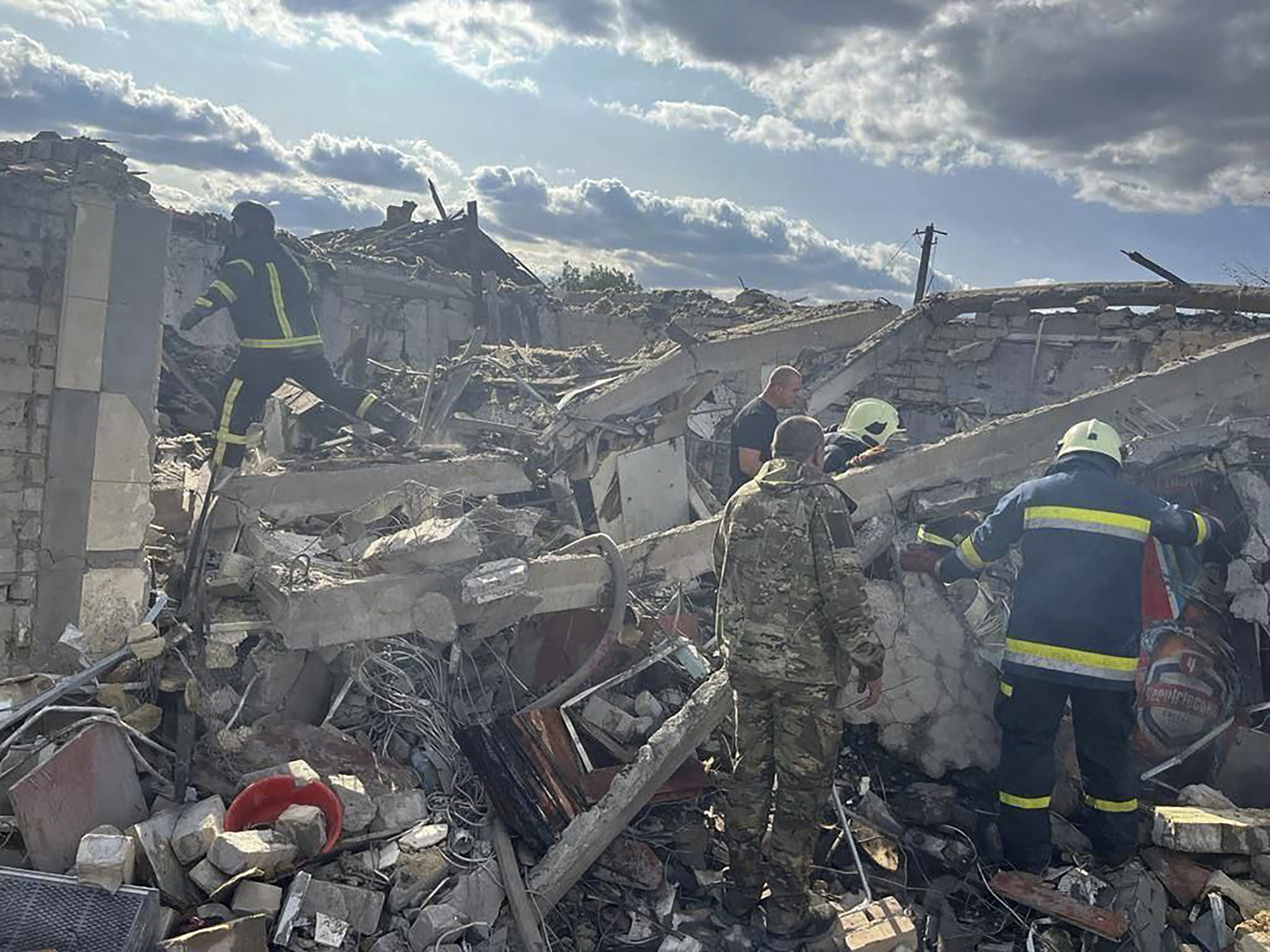 En esta fotografía proporcionada por la Oficina de Prensa Presidencial de Ucrania, trabajadores de emergencia buscan a las víctimas de un ataque con cohetes rusos que mató al menos a 47 personas en la aldea de Hroza, cerca de Kharkiv, Ucrania, el jueves 5 de octubre de 2023.