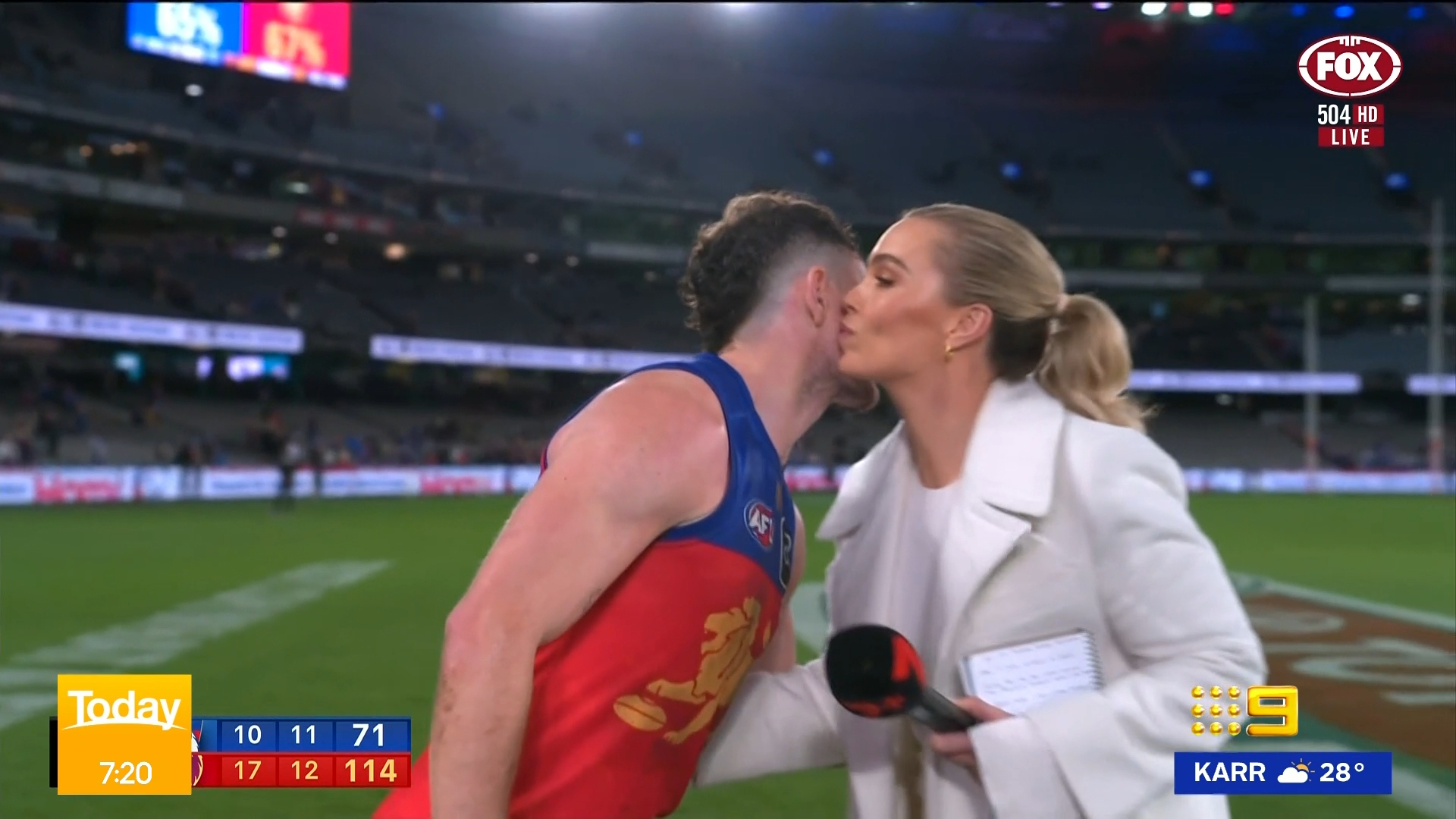 Lachie Neale kisses Abbey Holmes on the cheek.