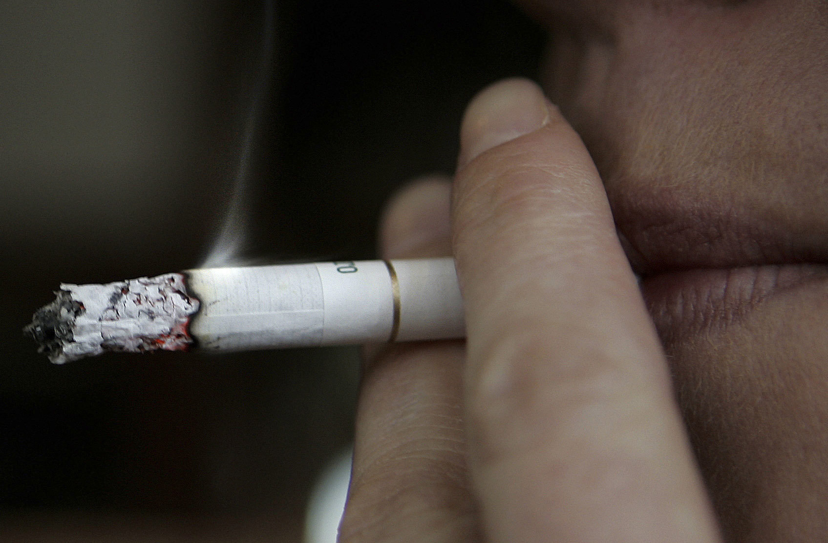 A woman smokes a cigarette.