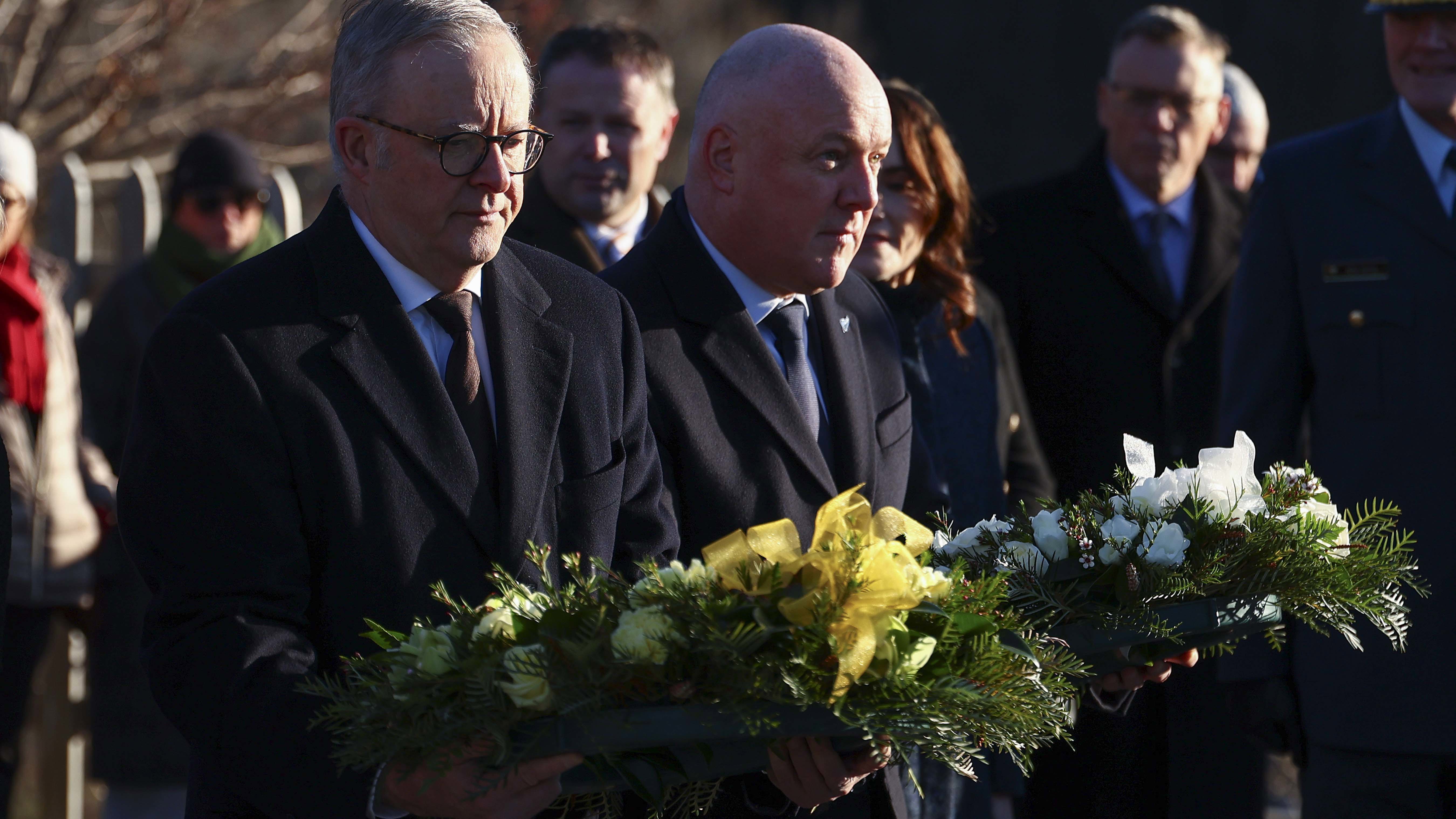 Australian Prime Minister Anthony Albanese and New Zealand Prime Minister Christopher Luxon carry wreaths to the memorial during a wreath laying ceremony at Arrowtown War Memorial Park on August 10, 2025 in Queenstown, New Zealand. 