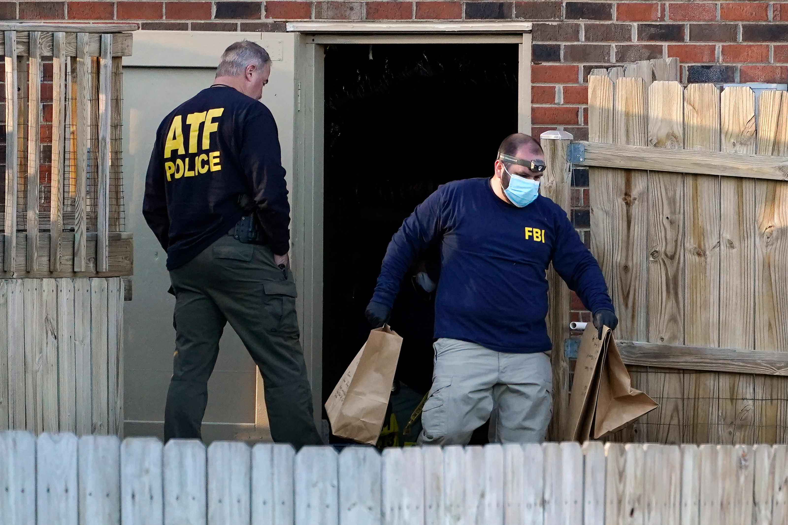 Investigators remove items from the basement of a home