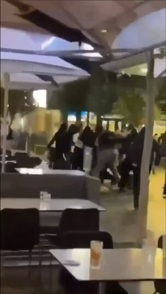 Several masked individuals approahced a table, before attacking a teenager.