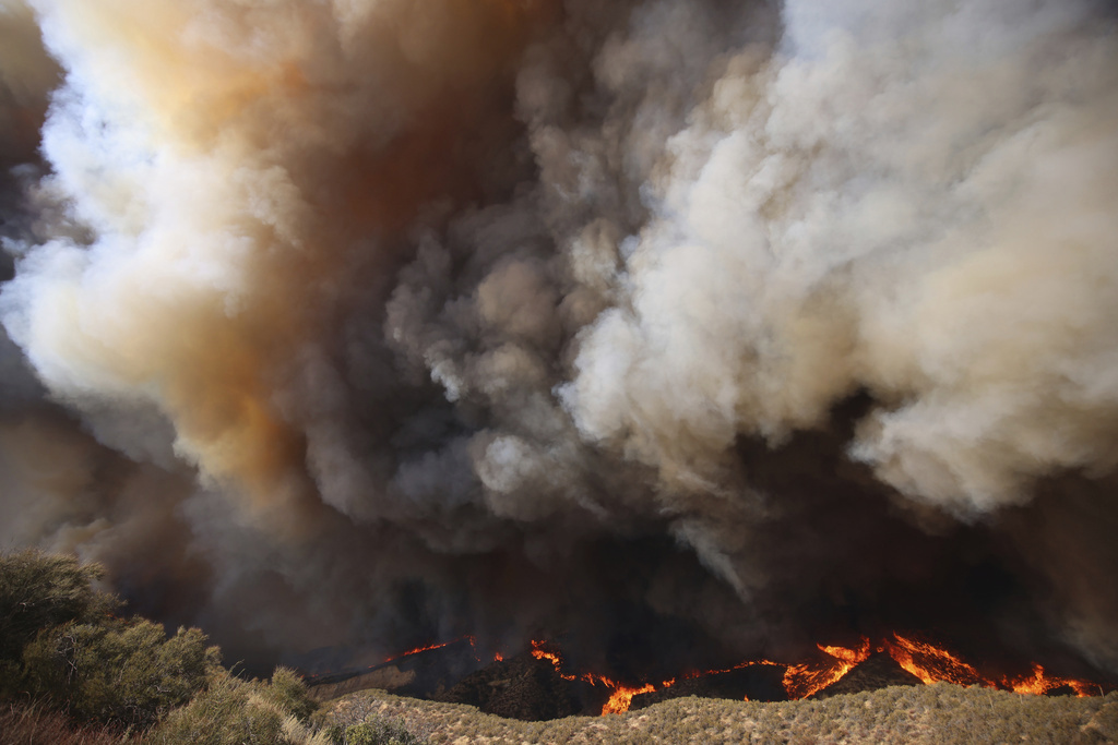 Plumes of smoke rise as the Hughes Fire burns in Castaic, Calf., Wednesday, Jan. 22, 2025. (AP Photo/Ethan Swope)