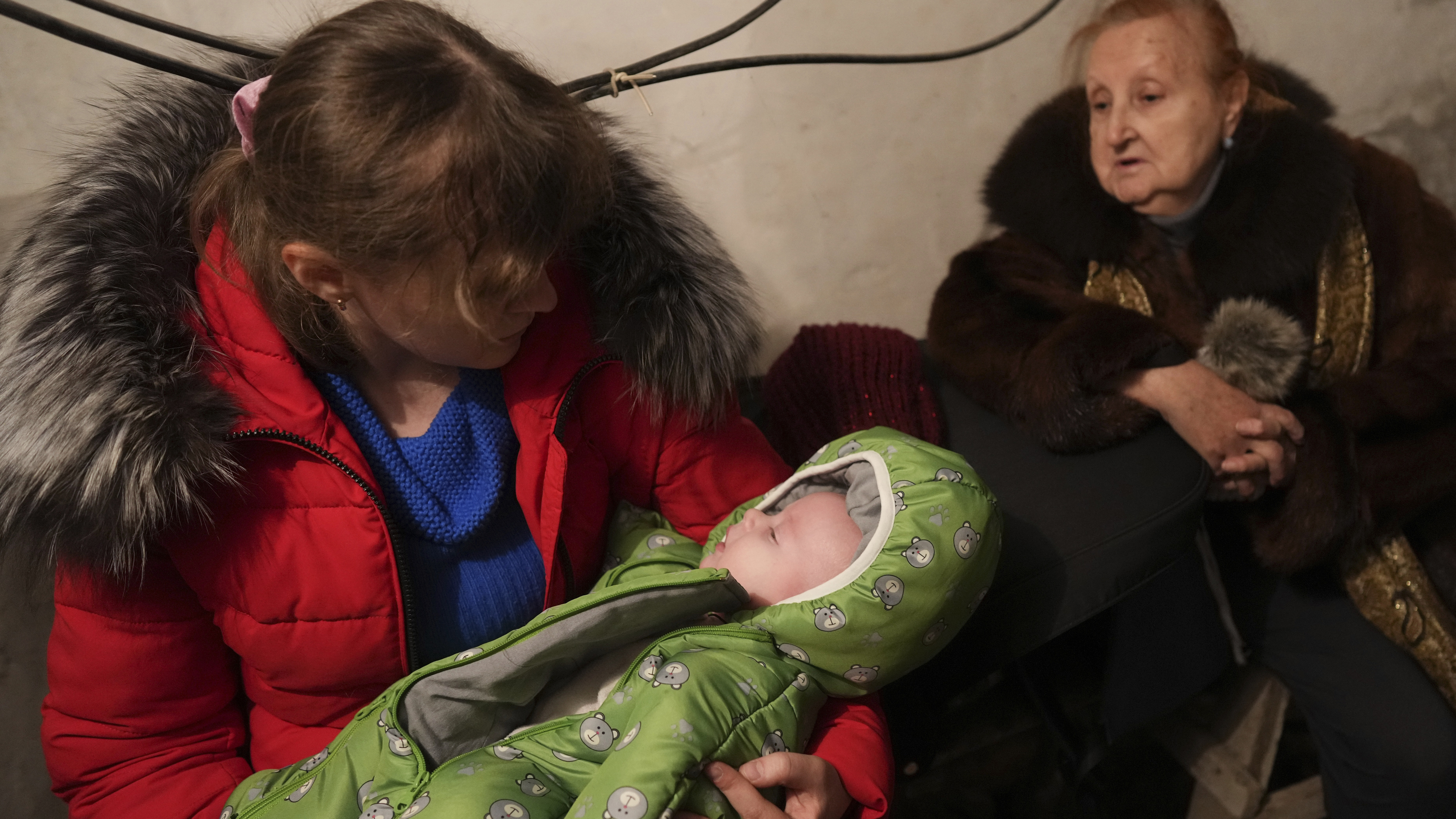 A woman holds her sleeping child in a shelter during Russian shelling, in Mariupol, Ukraine.