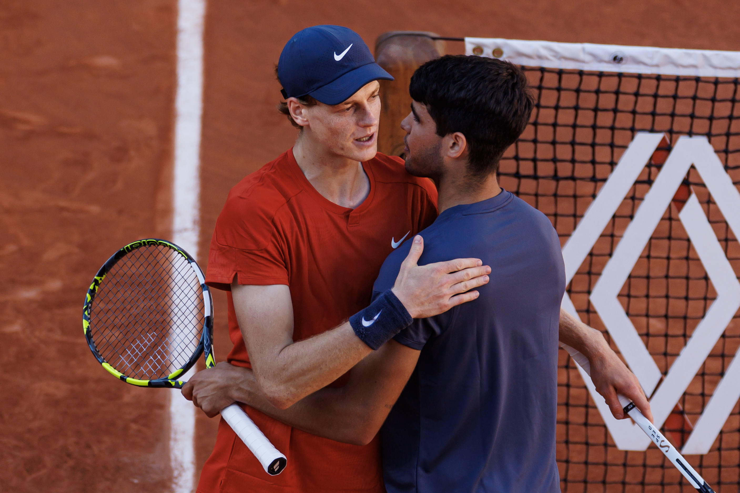 Carlos Alcaraz of Spain shakes hands with Jannik Sinner of Italy after beating him.