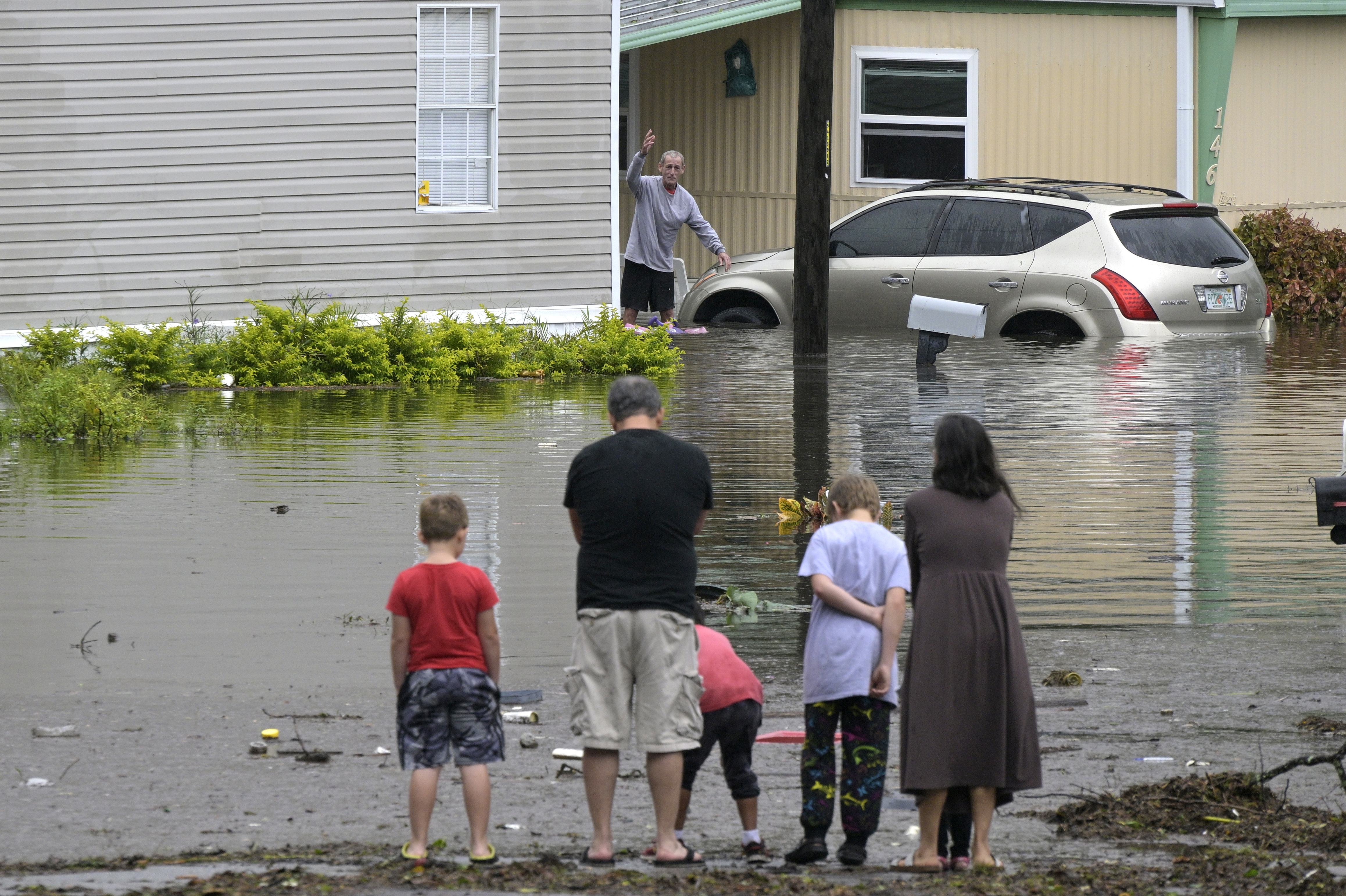 Residents check on one another in a flooded neighborhood in the aftermath of Hurricane Ian, Thursday, Sept. 29, 2022, in Orlando, Fla. (AP Photo/Phelan M. Ebenhack