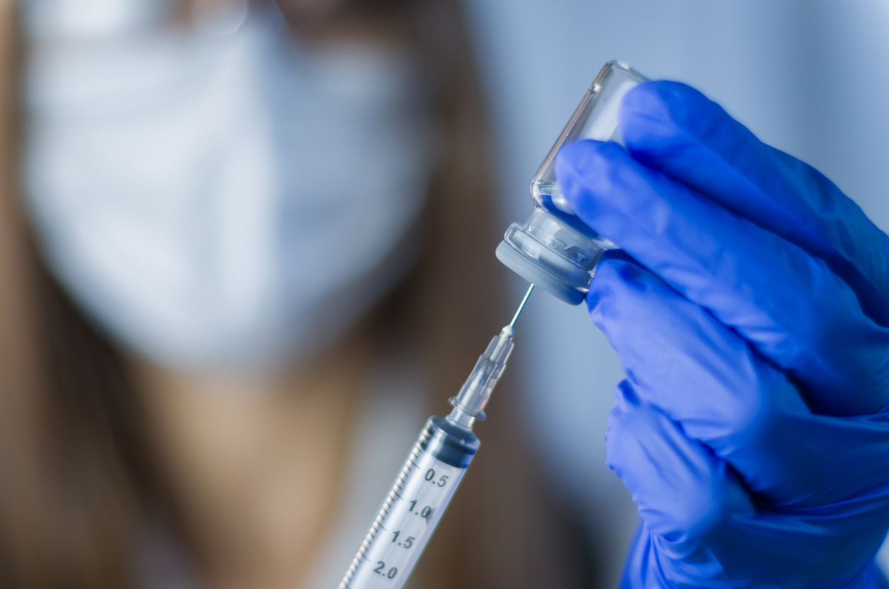 Stock image of doctor holding vaccination syringe
