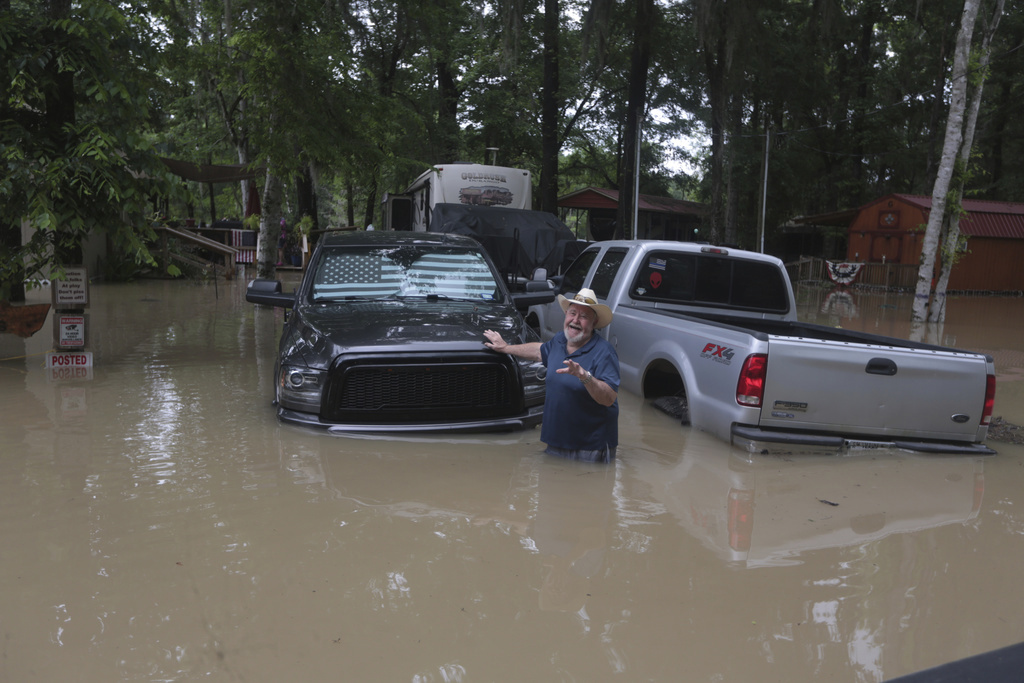 A man greets at Texas Parks & Wildlife Department game wardens as they arrive by boat to rescue residents from floodwaters in Liberty County, Texas.