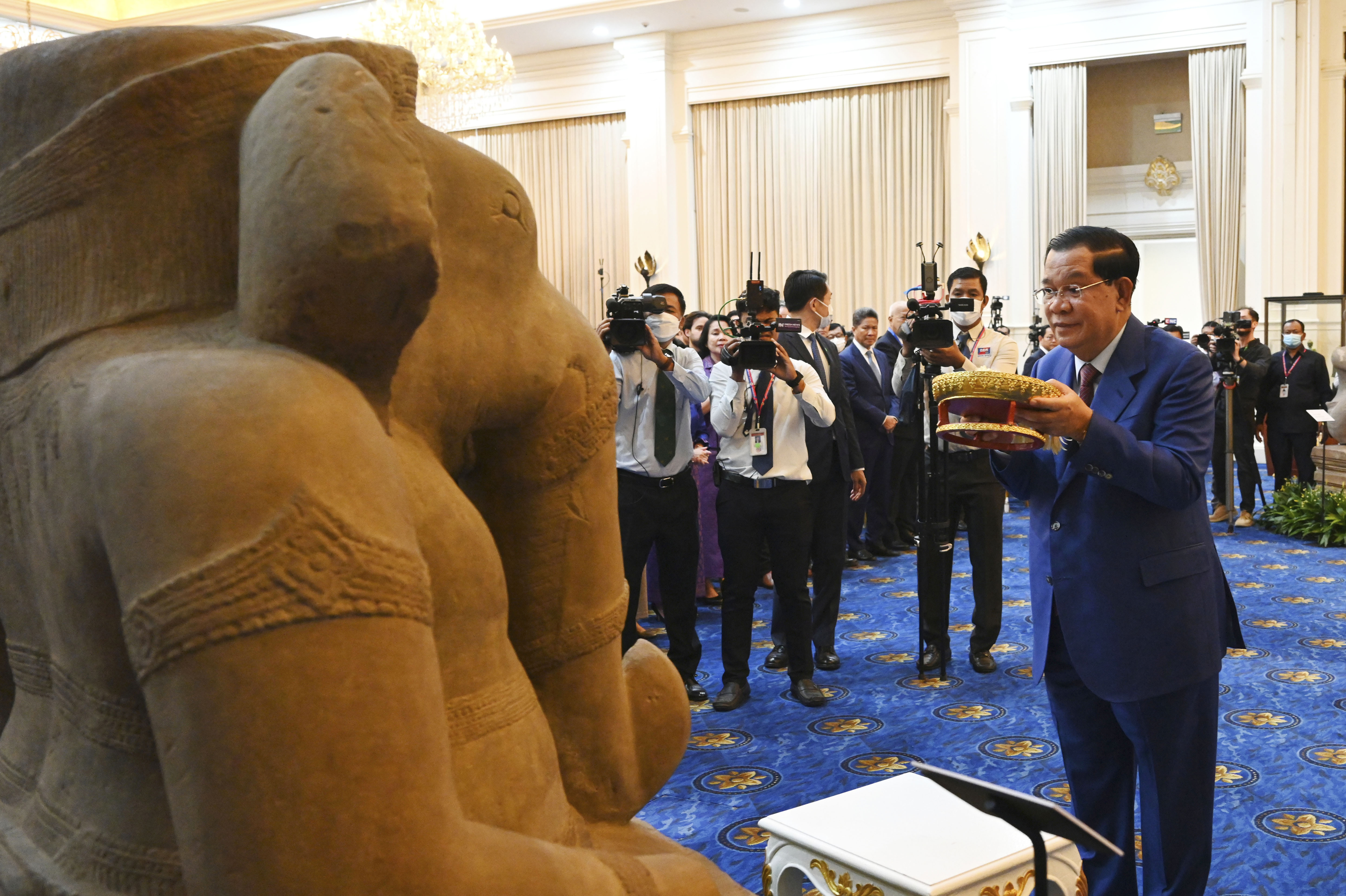 Cambodian Prime Minister Hun Sen, right, prays in front of a sandstone statue of Ganesha, at Peace Palace, in Phnom Penh, Cambodia, Friday, March 17, 2023.