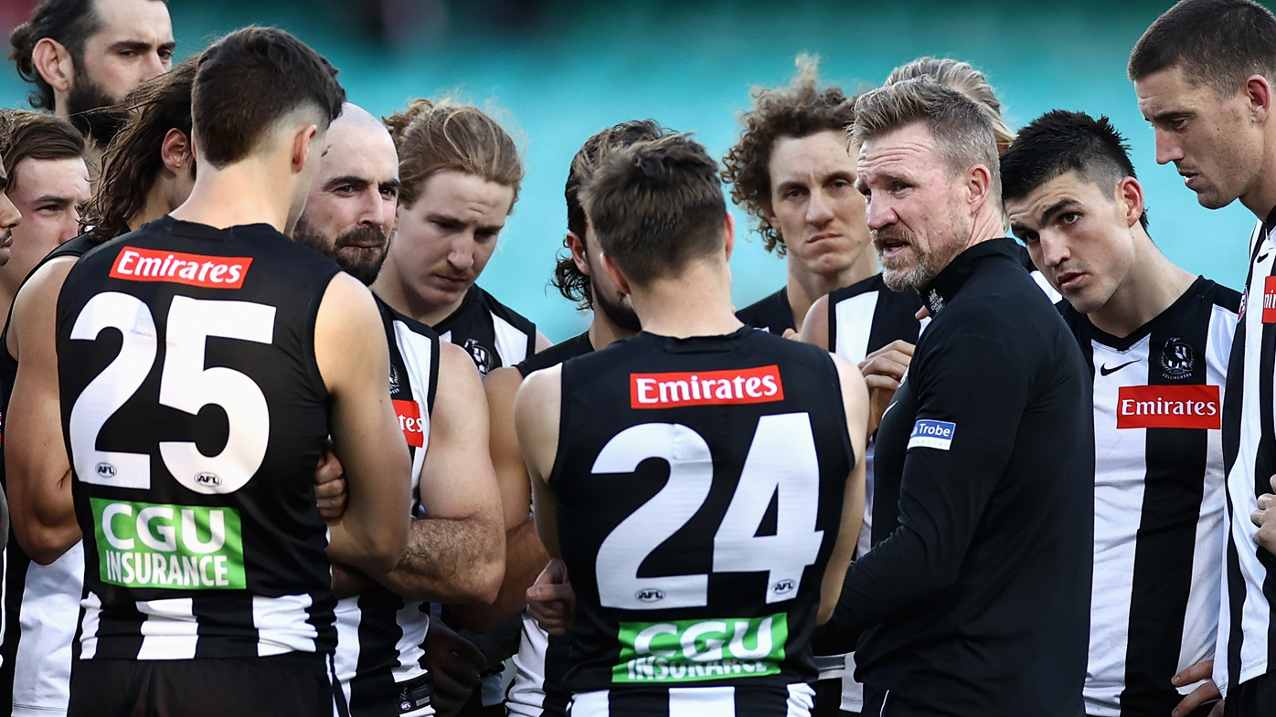 Collingwood Magpies players surround coach Nathan Buckley