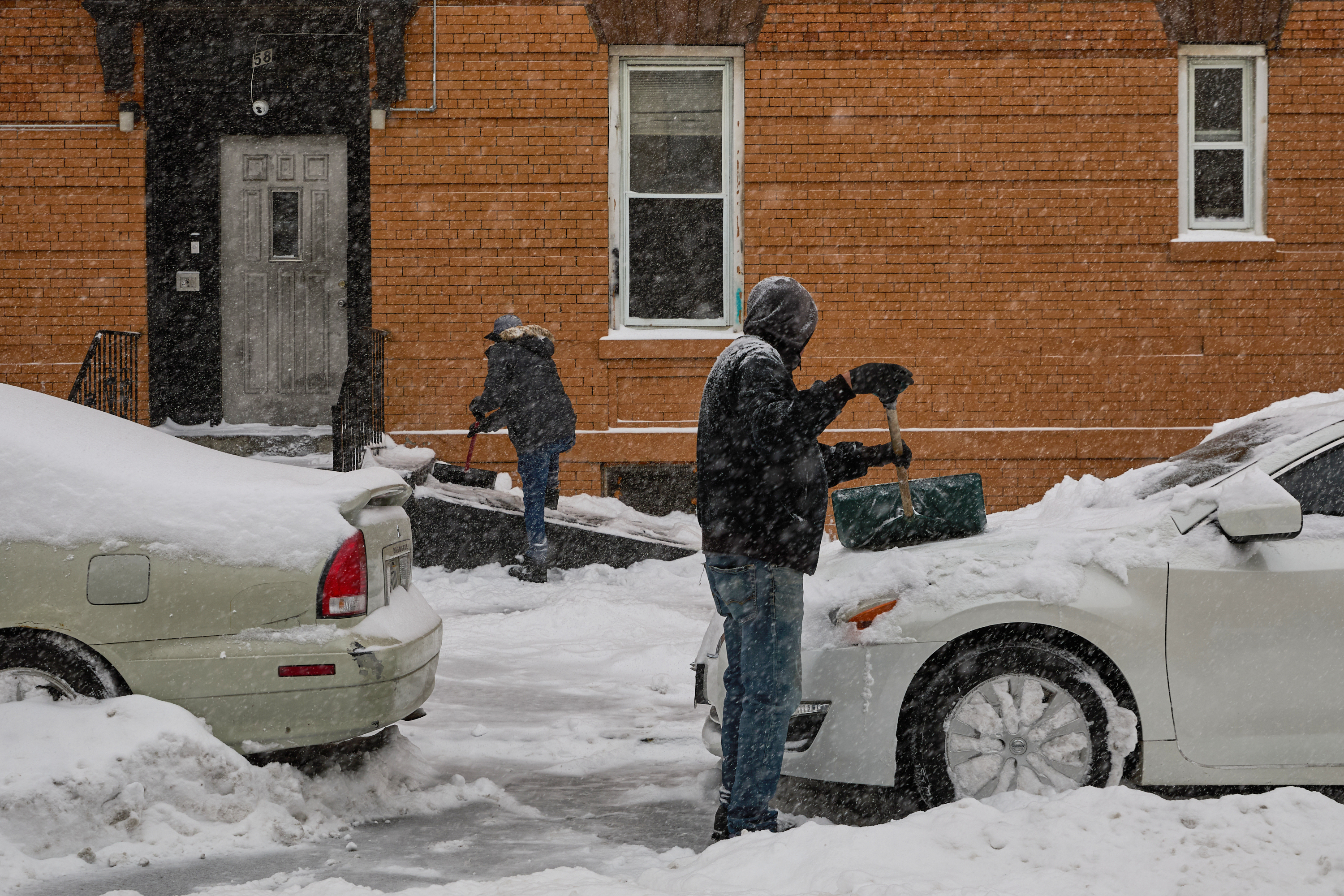 People shovel snow during a winter storm, Sunday, Jan. 25, 2026, in the Brooklyn borough of New York. 