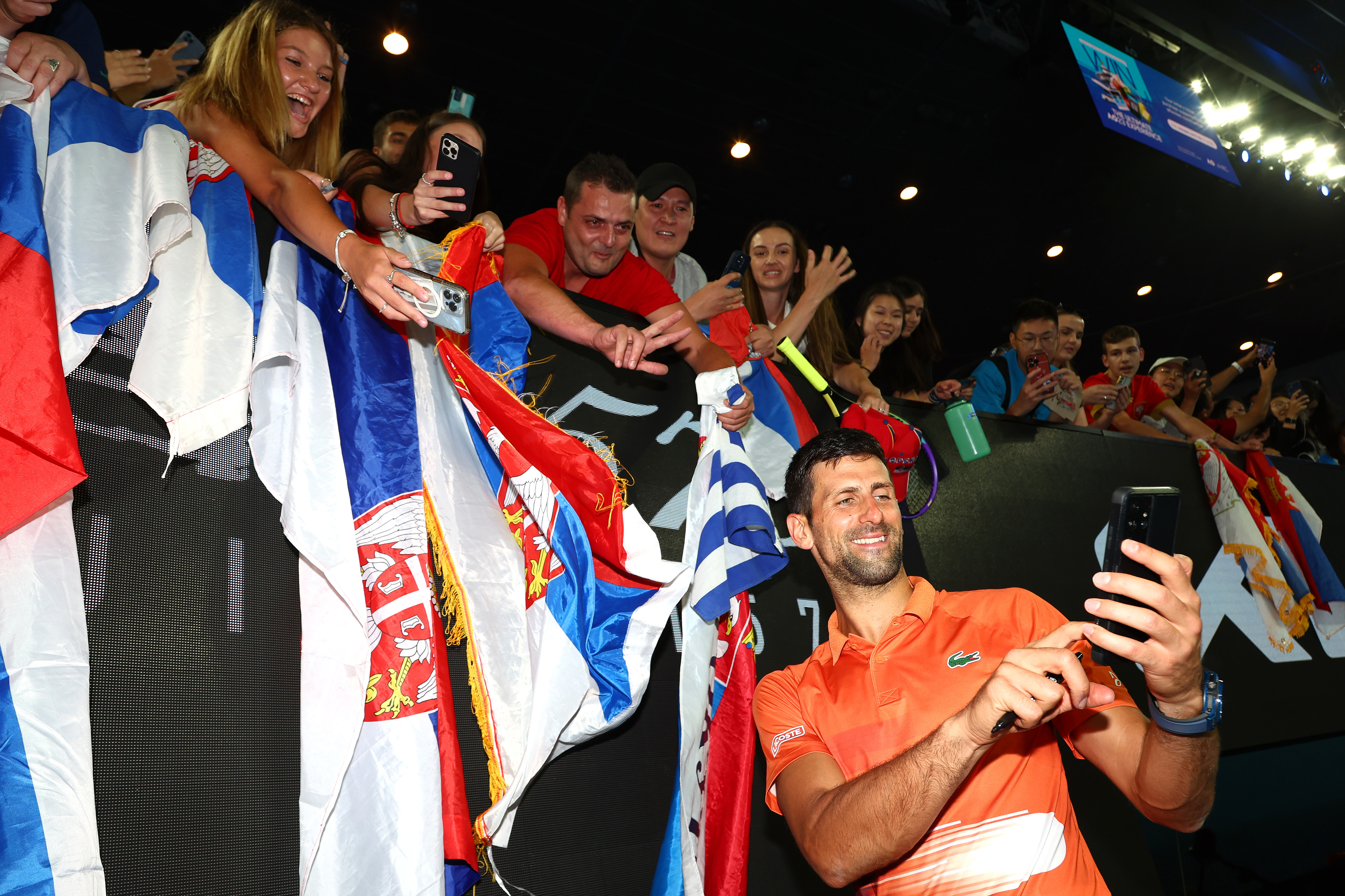 MELBOURNE, AUSTRALIA - JANUARY 13: Novak Djokovic of Serbia poses for a selfie with fans after the Arena Showdown charity match against Nick Kyrgios of Australia ahead of the 2023 Australian Open at Melbourne Park on January 13, 2023 in Melbourne, Australia. (Photo by Graham Denholm/Getty Images)