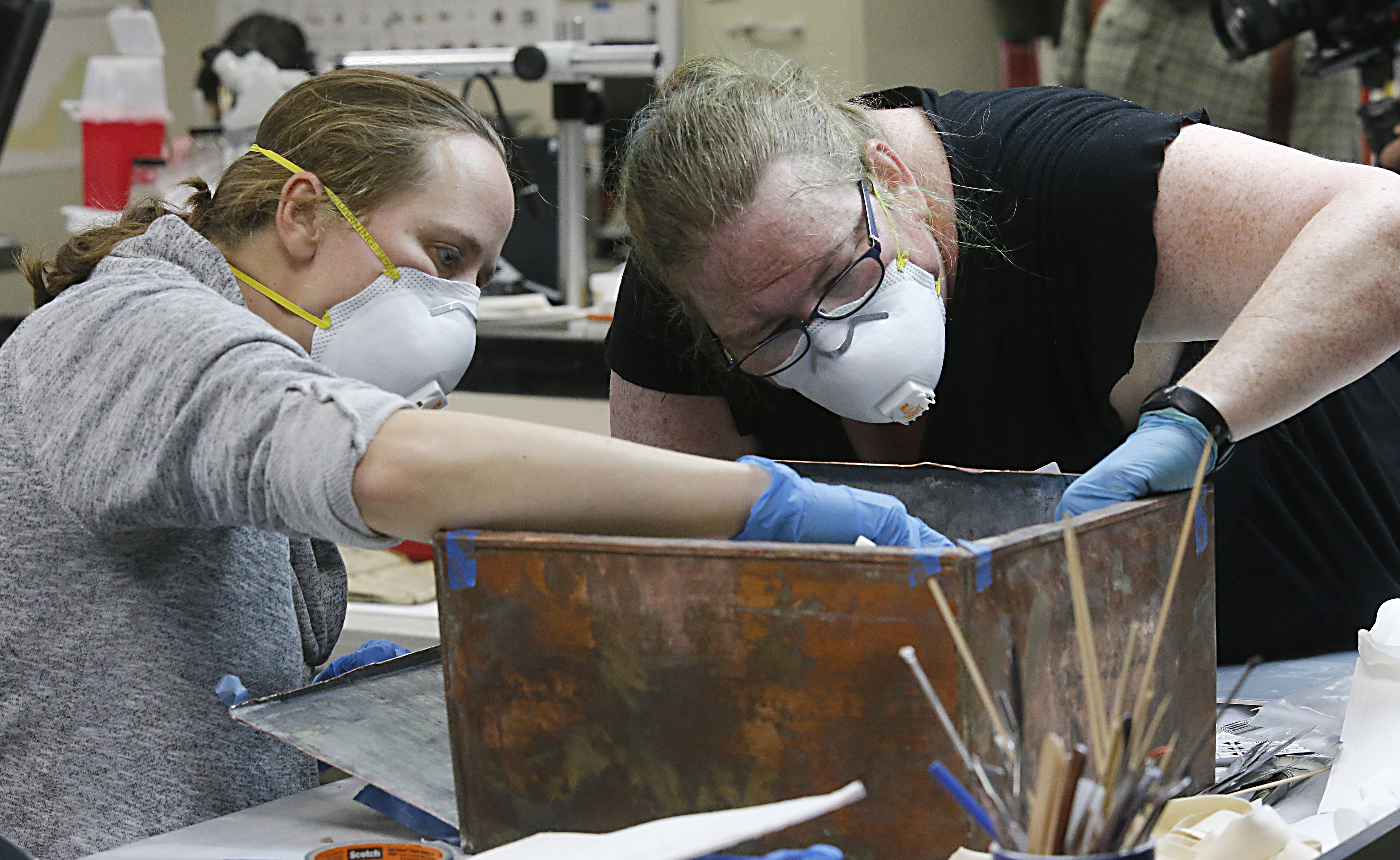 Sue Donovan, left, and Kate Ridgeway, right, dig into the artefacts inside the copper box recovered from the base of the Robert E. Lee monument in Richmond, Virginia. 