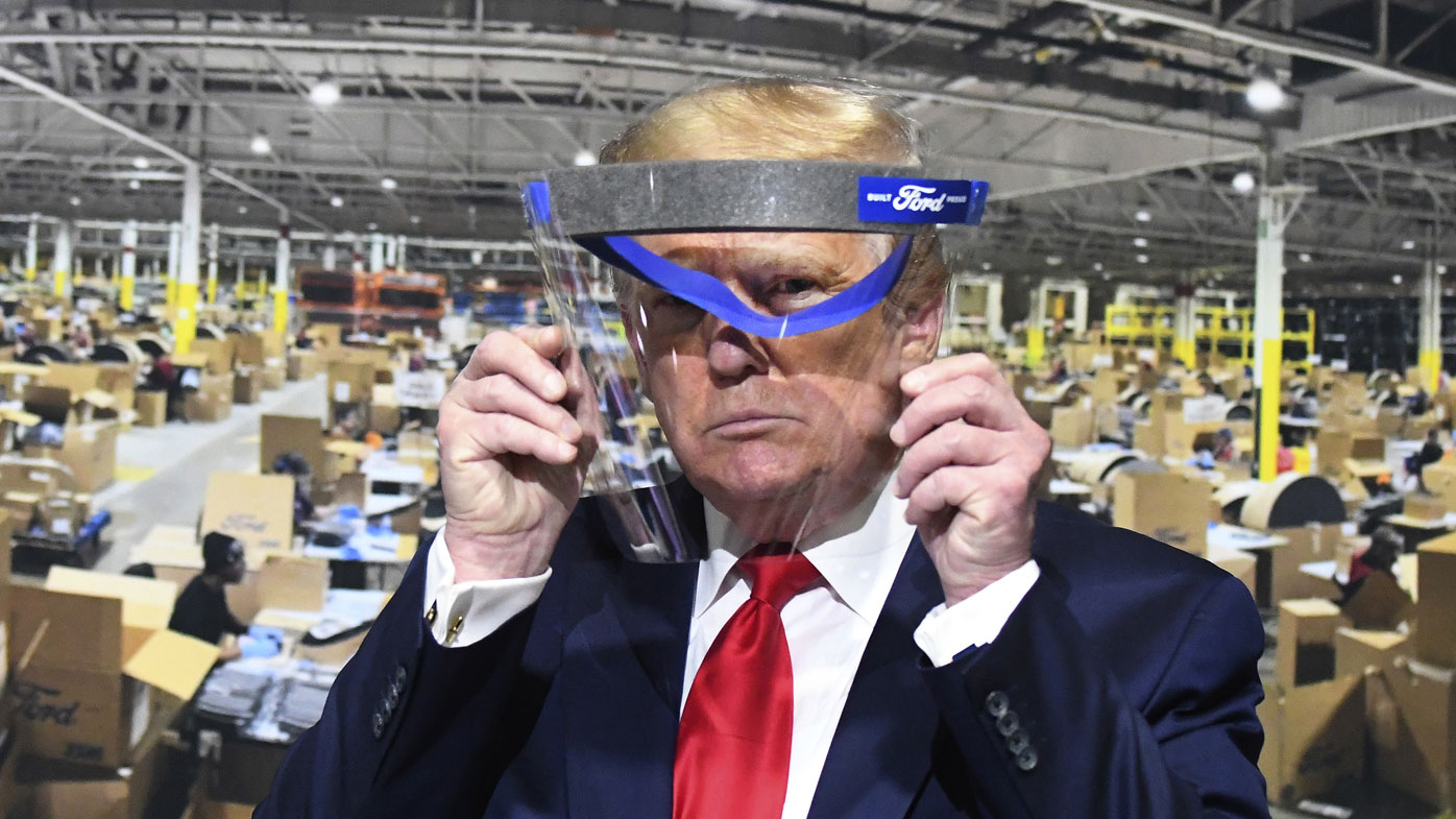 President Donald Trump looks through a face shield while touring Ford Motor Co.'s Rawsonville Components Plant in Michigan.