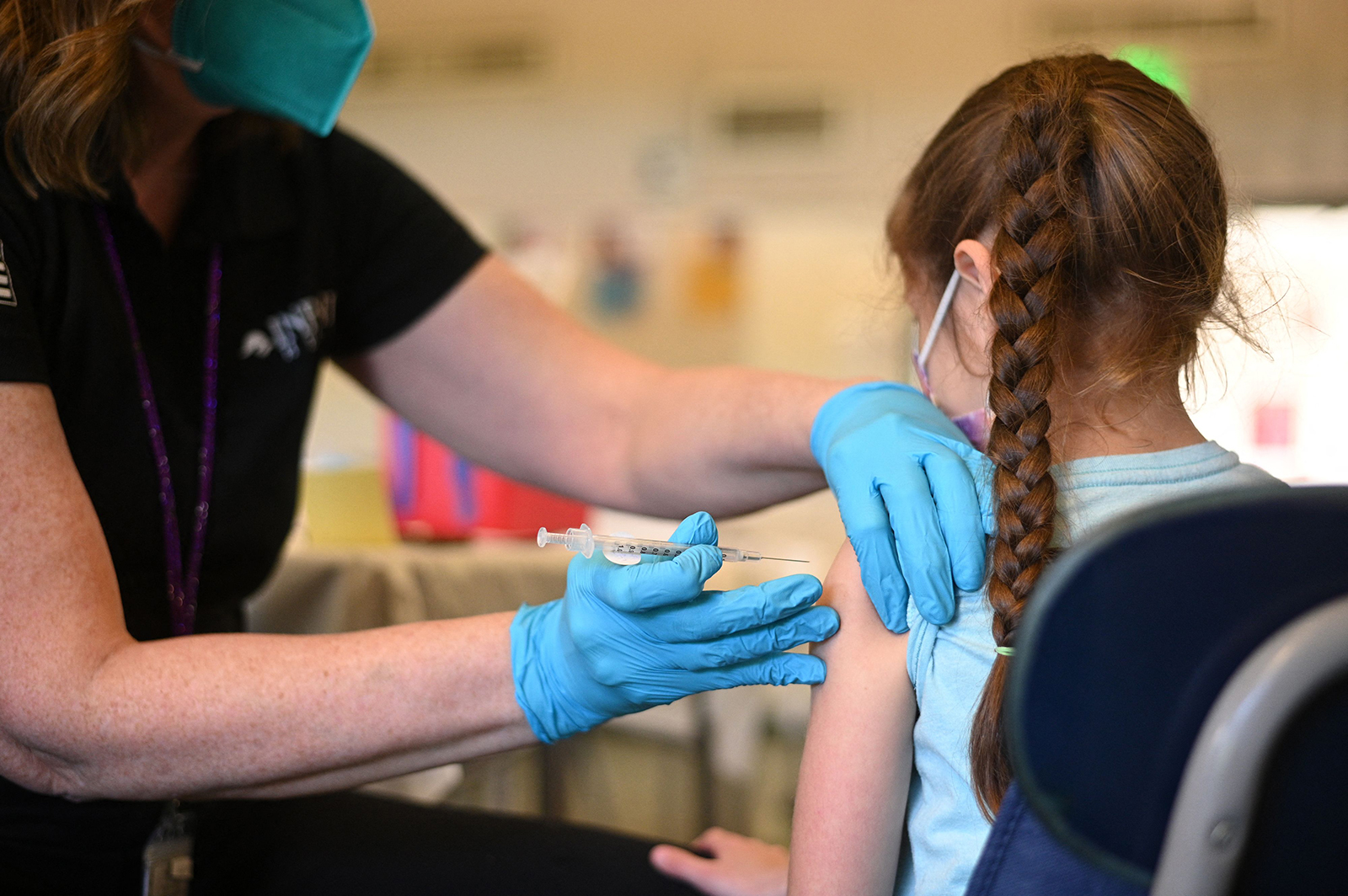 A nurse administers a pediatric dose of the Covid-19 vaccine to a girl at a L.A. Care Health Plan vaccination clinic at Los Angeles Mission College in the Sylmar neighborhood in Los Angeles, California, January 19, 2022 