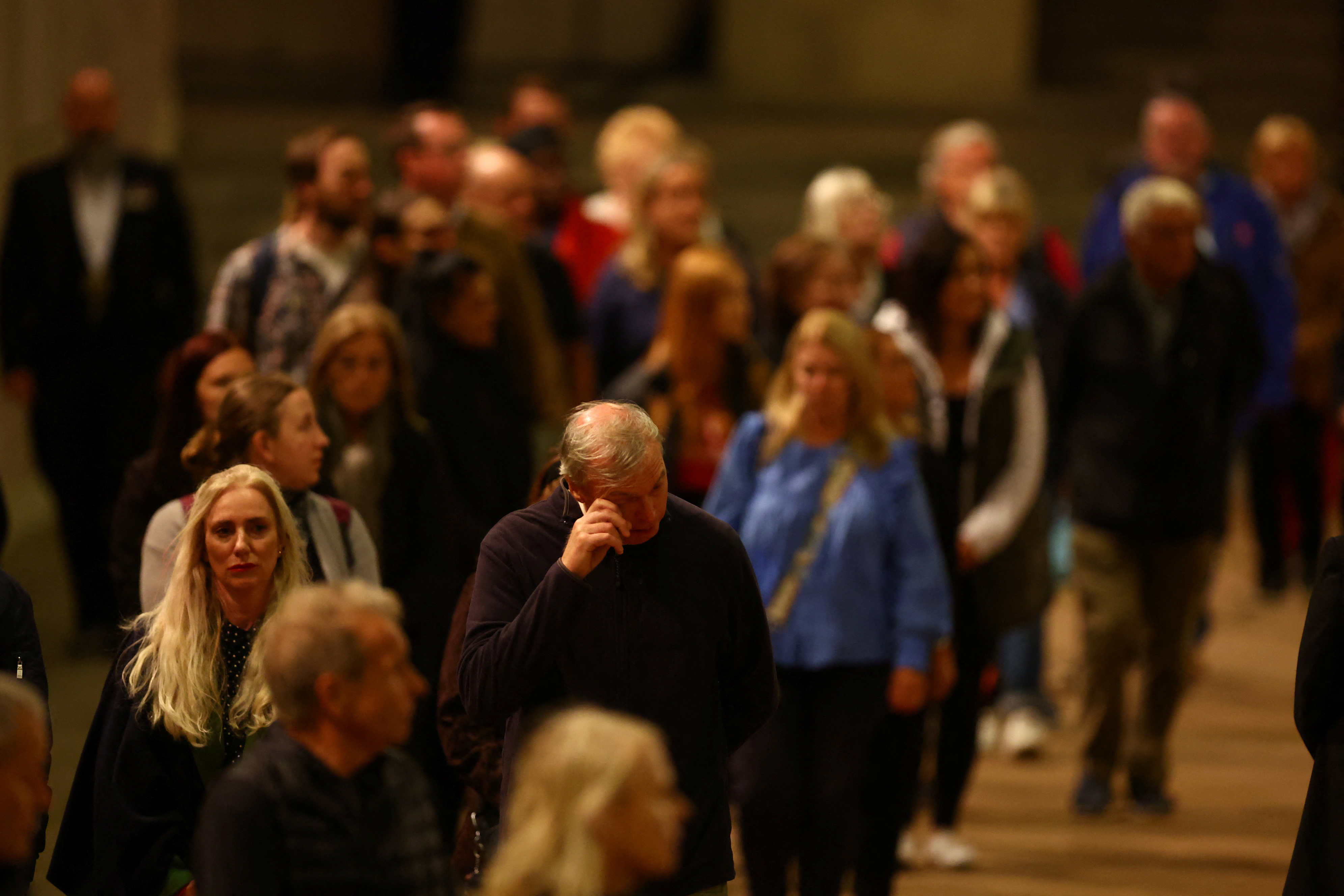 People react as they pay their respects passing the coffin of Britain's Queen Elizabeth ll, inside Westminster Hall on September 16, 2022 in London, England. Queen Elizabeth II's children mount a family vigil over her coffin lying in state in Westminster Hall. Queen Elizabeth II died at Balmoral Castle in Scotland on September 8, 2022, and is succeeded by her eldest son, King Charles III. (Photo by Hannah Mckay - WPA Pool / Getty Images)