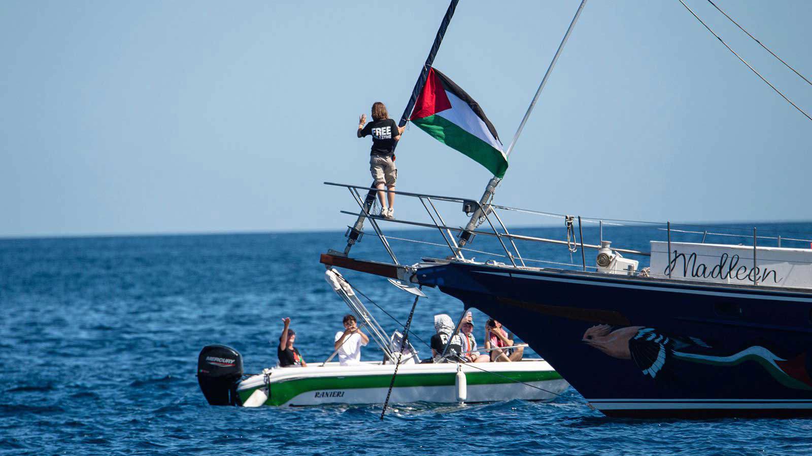 Climate activist Greta Thunberg stands next to a Palestinian flag after boarding the Madleen and before setting sail for Gaza with the Freedom Flotilla Coalition, leaving the Sicilian port of Catania on June 1.