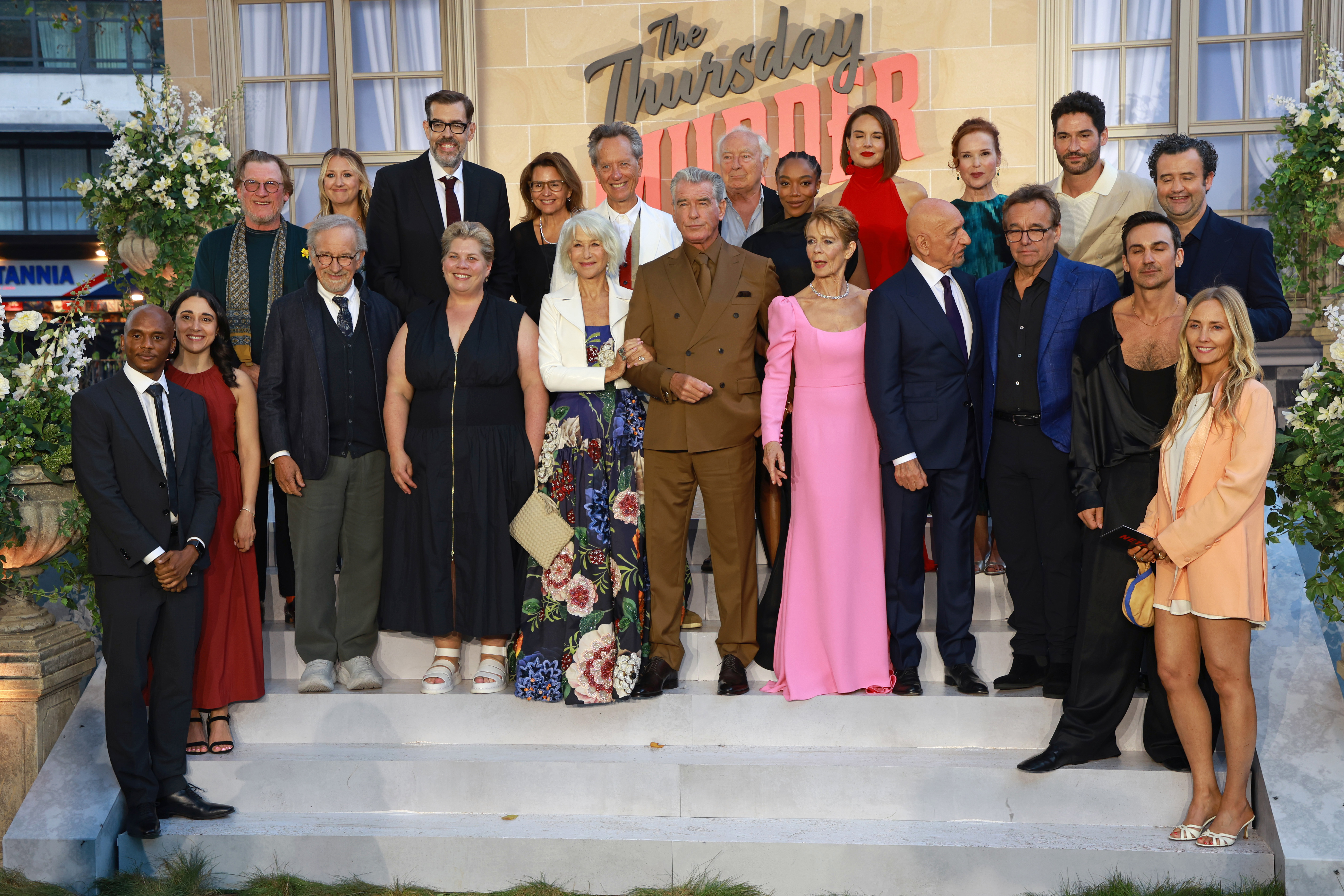 LONDON, ENGLAND - AUGUST 21: (L-R) Jerome Hill, Maria Fortese, Director of Development, Amblin Partners, Geoff Bell, Steven Spielberg, Suzanne Heathcote, Richard Osman, Katy Brand, Holly Bario, President, Amblin Entertainment, Dame Helen Mirren, Richard E. Grant, Pierce Brosnan, Paul Freeman, Naomi Ackie, Celia Imrie, Ingrid Oliver, Sir Ben Kingsley, Jennifer Todd, Chris Columbus, Tom Ellis, Henry Lloyd-Hughes, Daniel Mays and Cassidy Lange attend "The Thursday Murder Club" UK Premiere at Leices