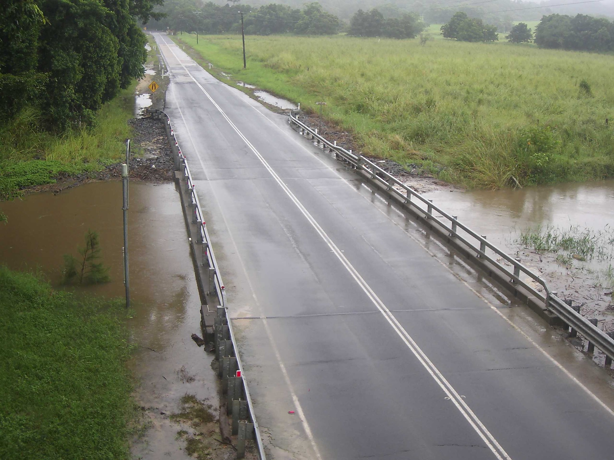The muddy brown water of Bushy Creek swirled below the bridge on Mount Molloy Road.